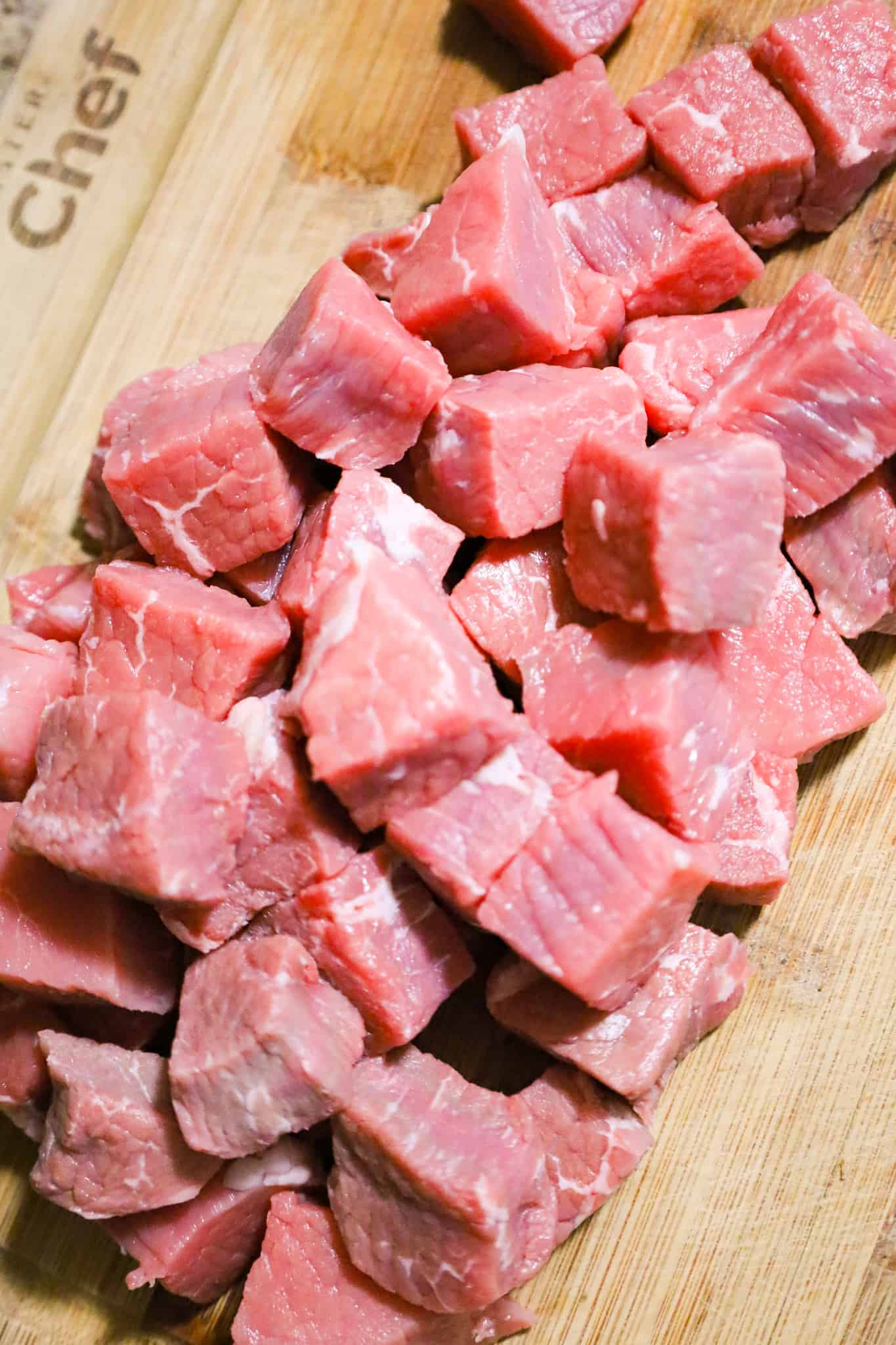 raw steak chunks on a cutting board