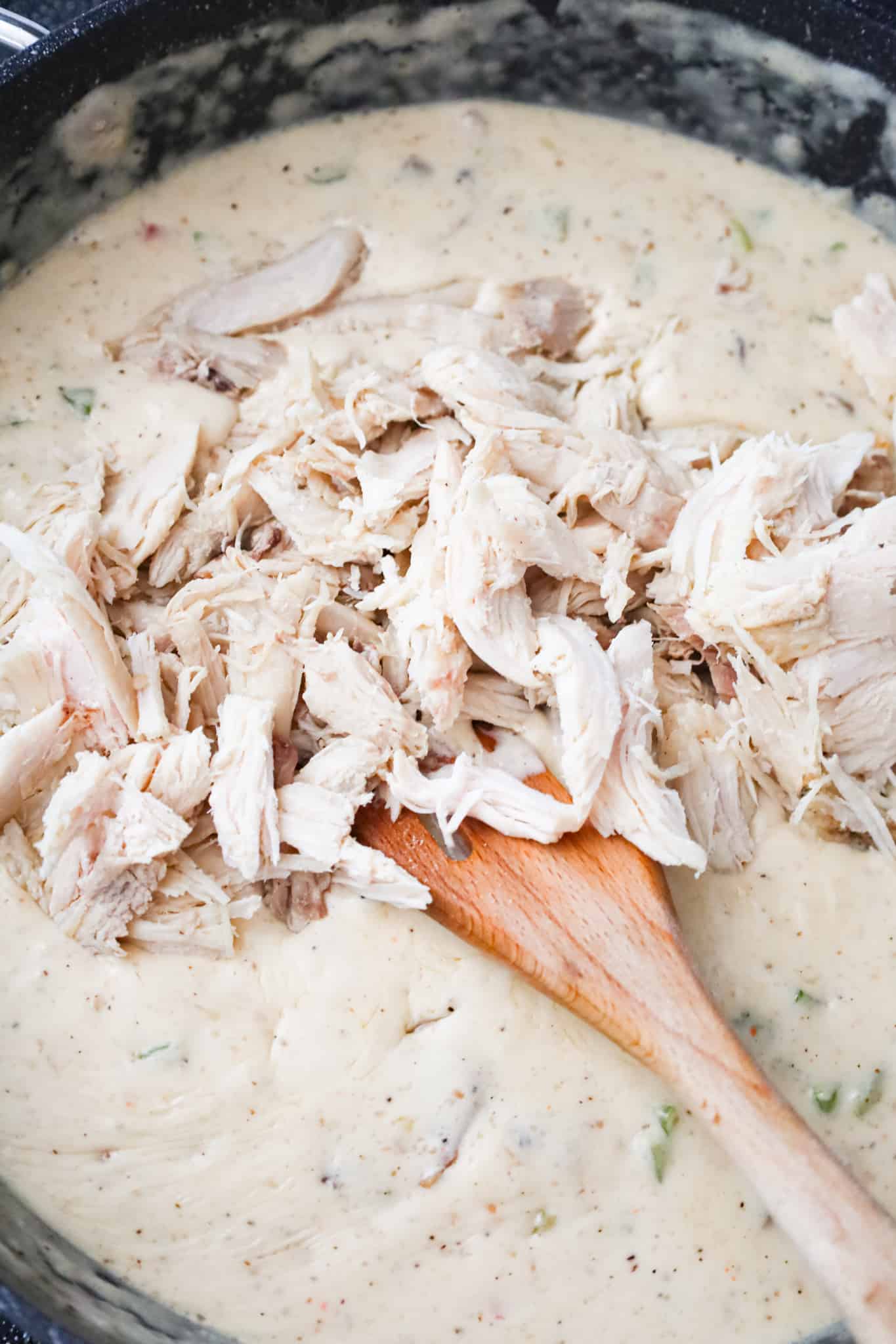 cooked, shredded turkey on top of cream sauce mixture in a skillet