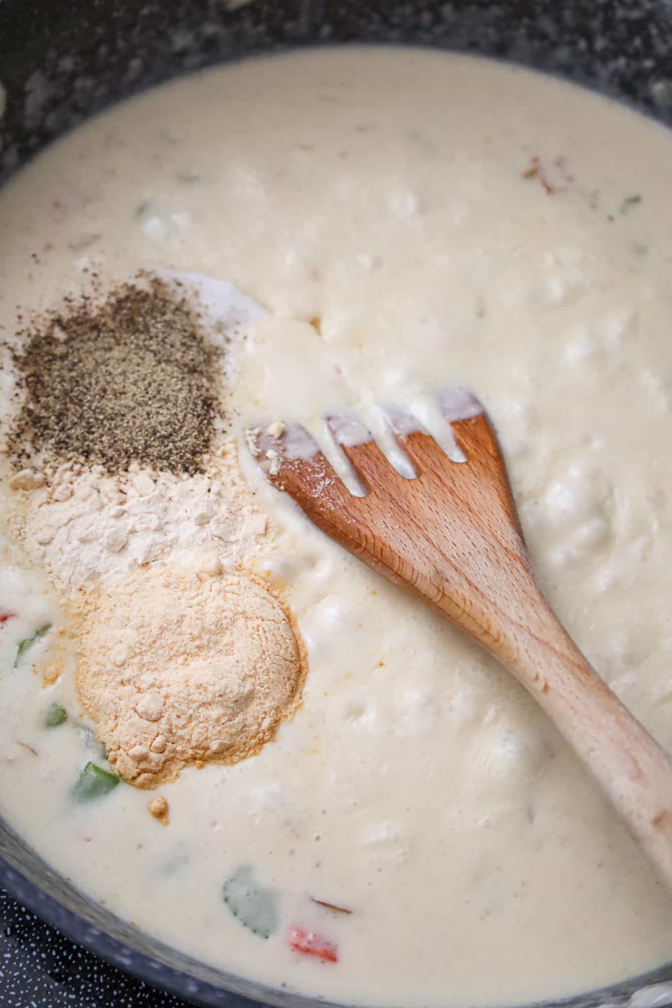 spices added to a creamy vegetable mixture in a skillet