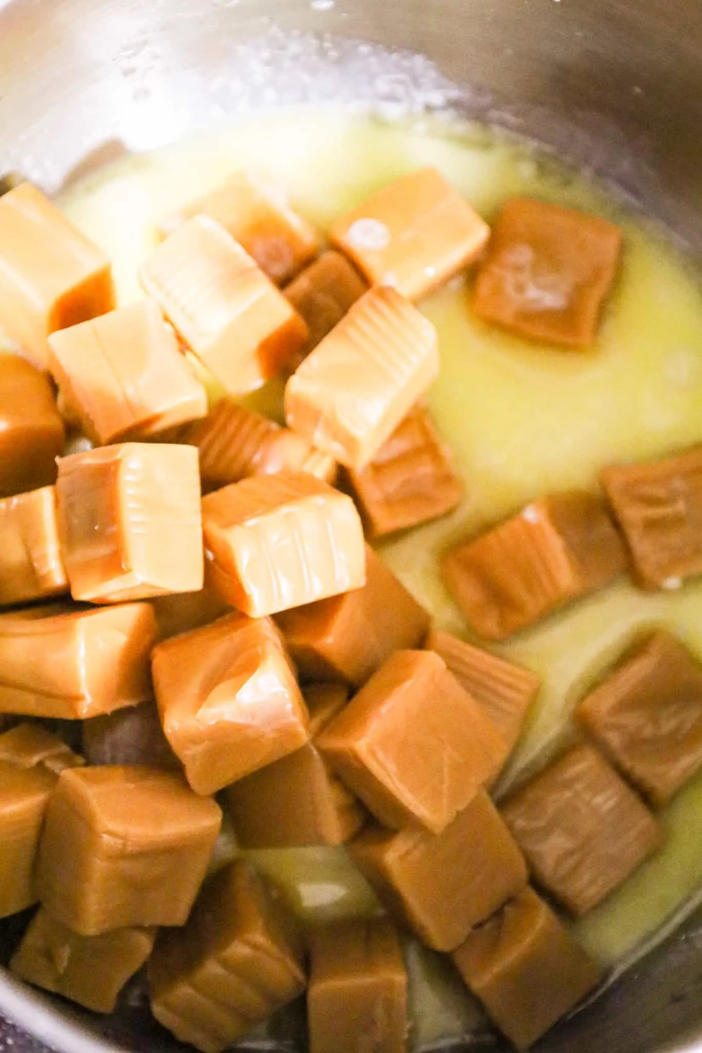 Kraft caramels on top of melted butter and milk in a sauce pot