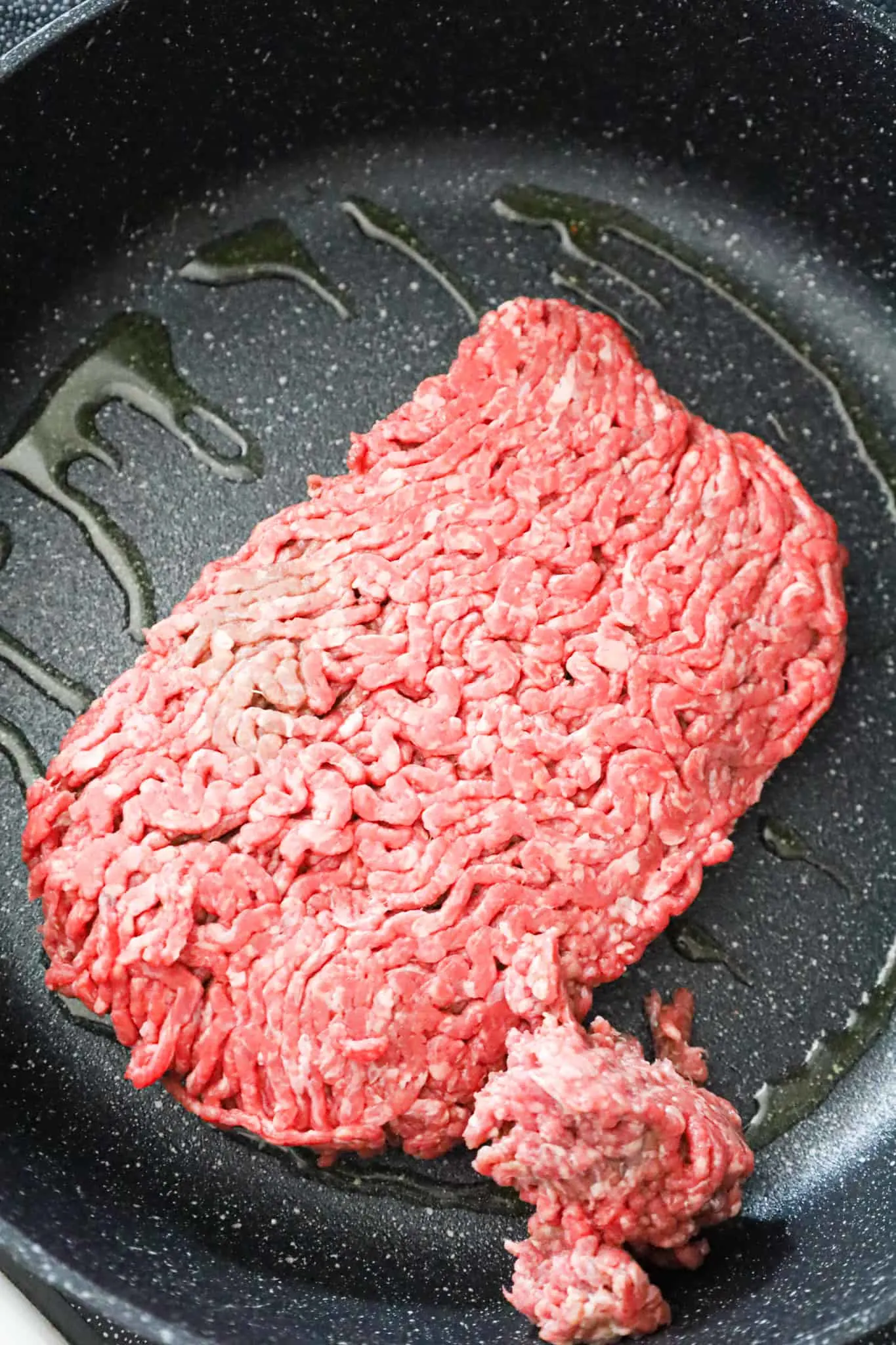 raw ground beef and olive oil in a skillet