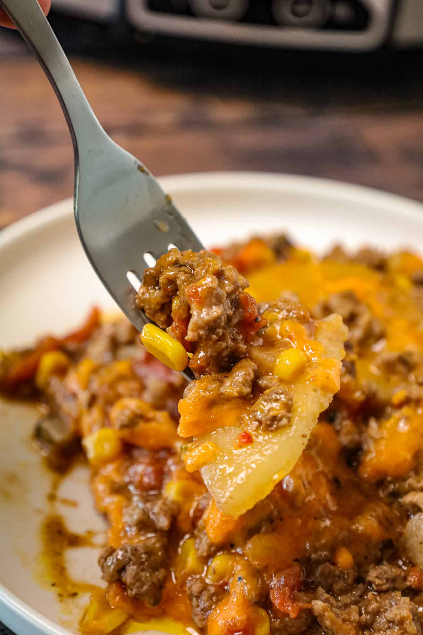 Crock Pot Cowboy Casserole is a hearty slow cooker dinner recipe loaded with ground beef, diced tomatoes, potatoes, corn and cheese.