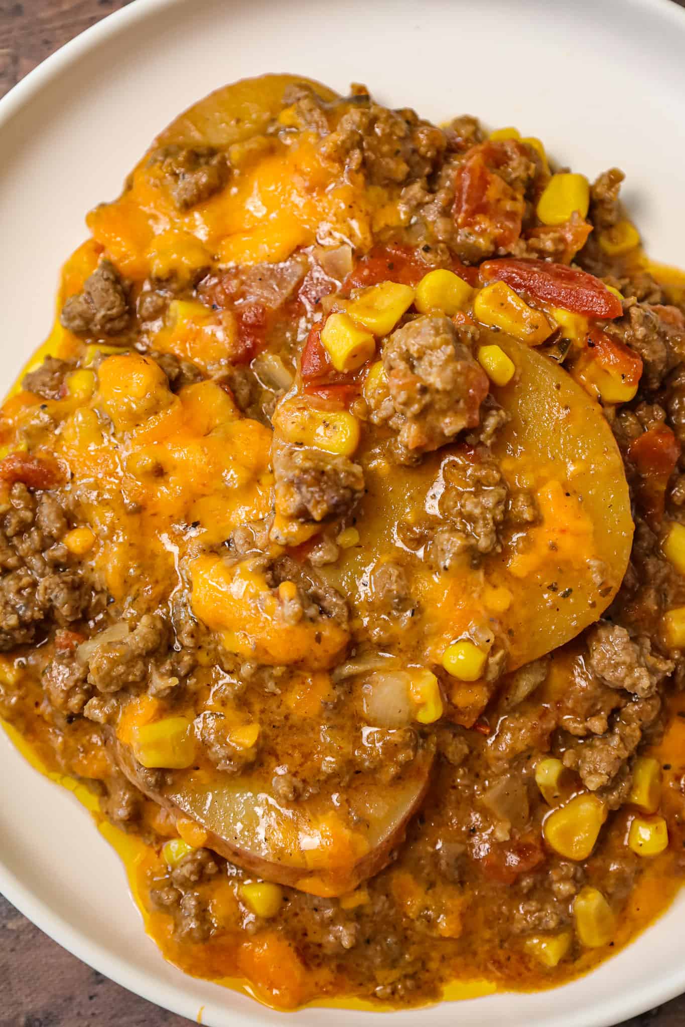 Crock Pot Cowboy Casserole is a hearty slow cooker dinner recipe loaded with ground beef, diced tomatoes, potatoes, corn and cheese.