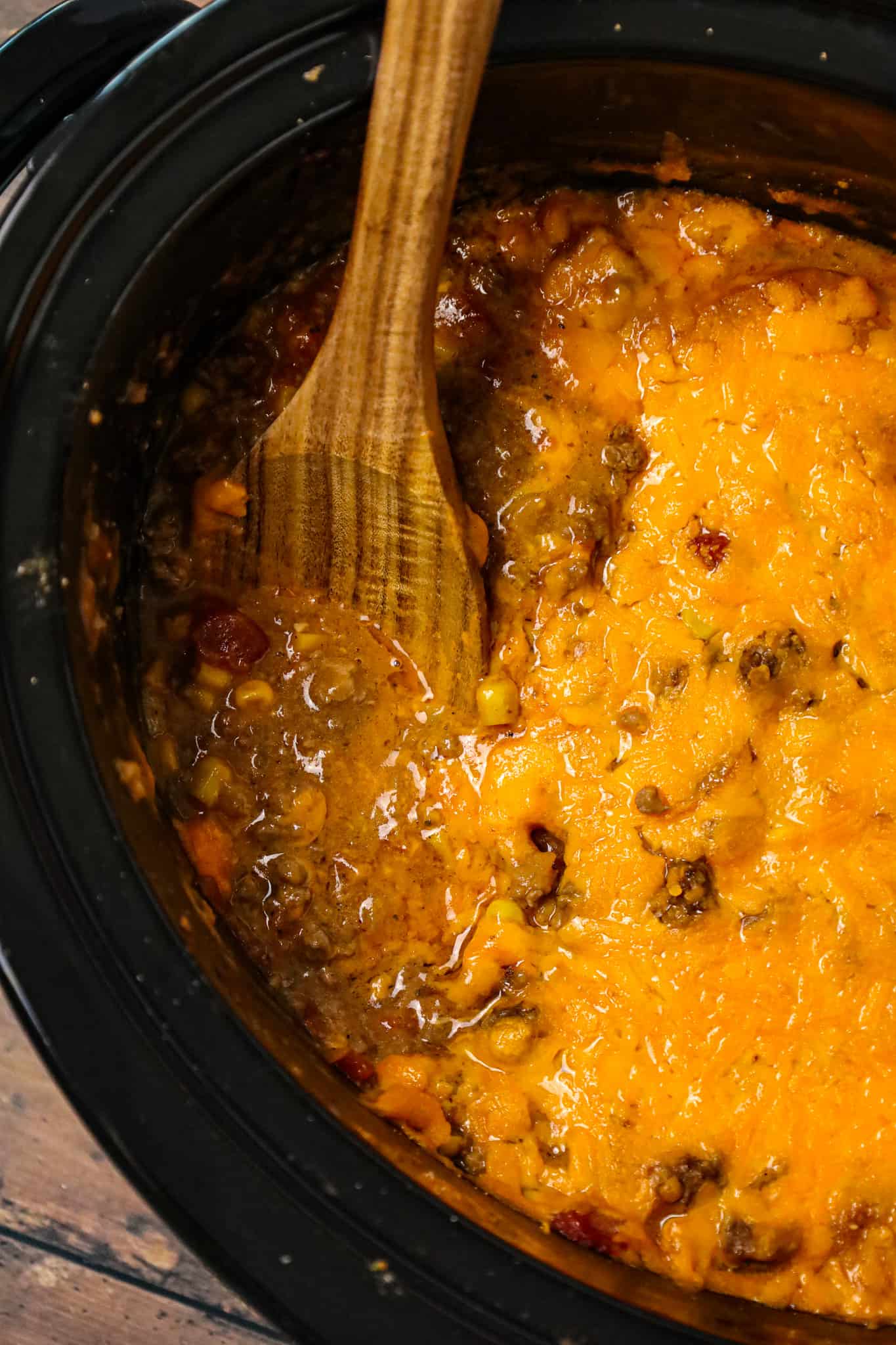 Crock Pot Cowboy Casserole is a hearty slow cooker dinner recipe loaded with ground beef, diced tomatoes, potatoes, corn and cheese.