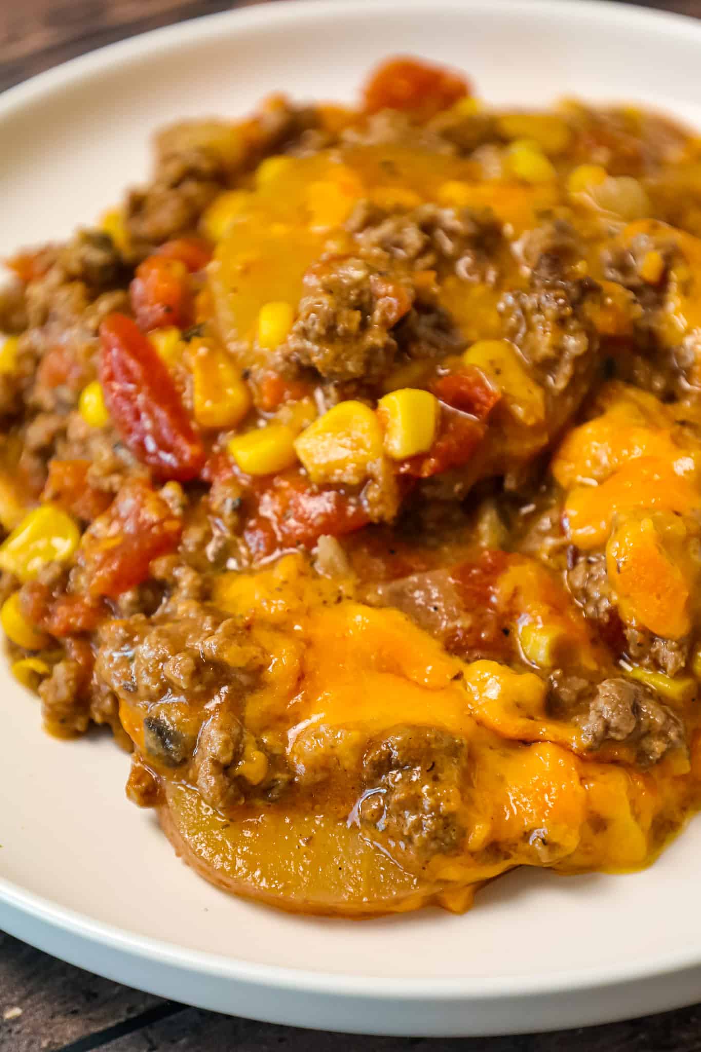 Crock Pot Cowboy Casserole is a hearty slow cooker dinner recipe loaded with ground beef, diced tomatoes, potatoes, corn and cheese.