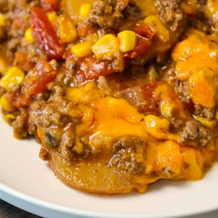 Crock Pot Cowboy Casserole is a hearty slow cooker dinner recipe loaded with ground beef, diced tomatoes, potatoes, corn and cheese.