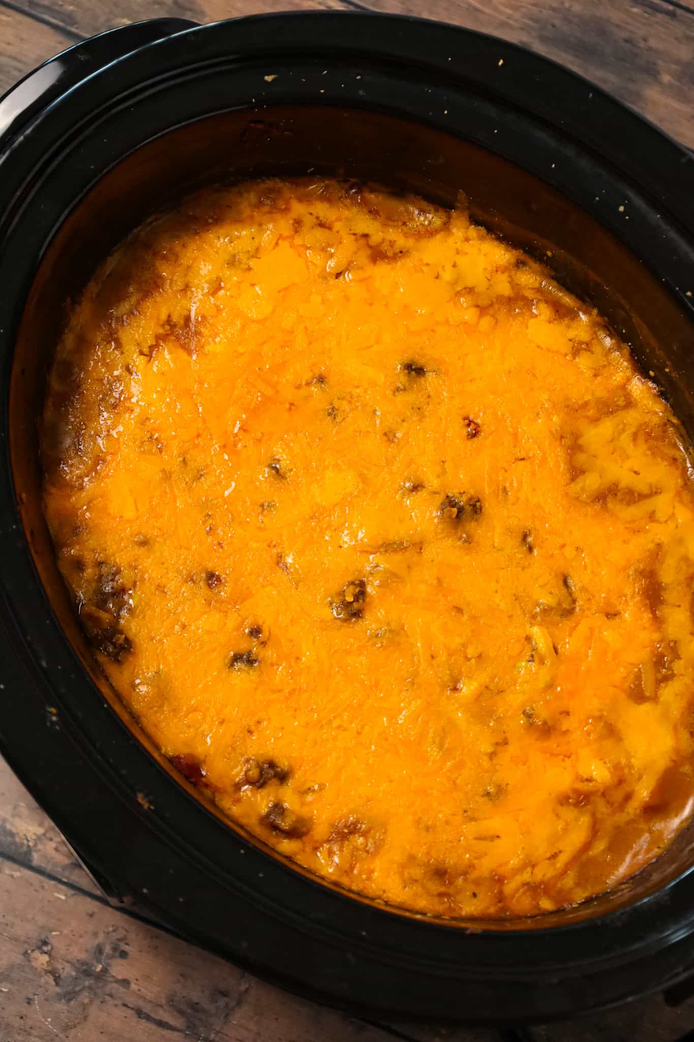 Crock Pot Cowboy Casserole is a hearty slow cooker dinner recipe loaded with ground beef, diced tomatoes, potatoes, corn and cheese.