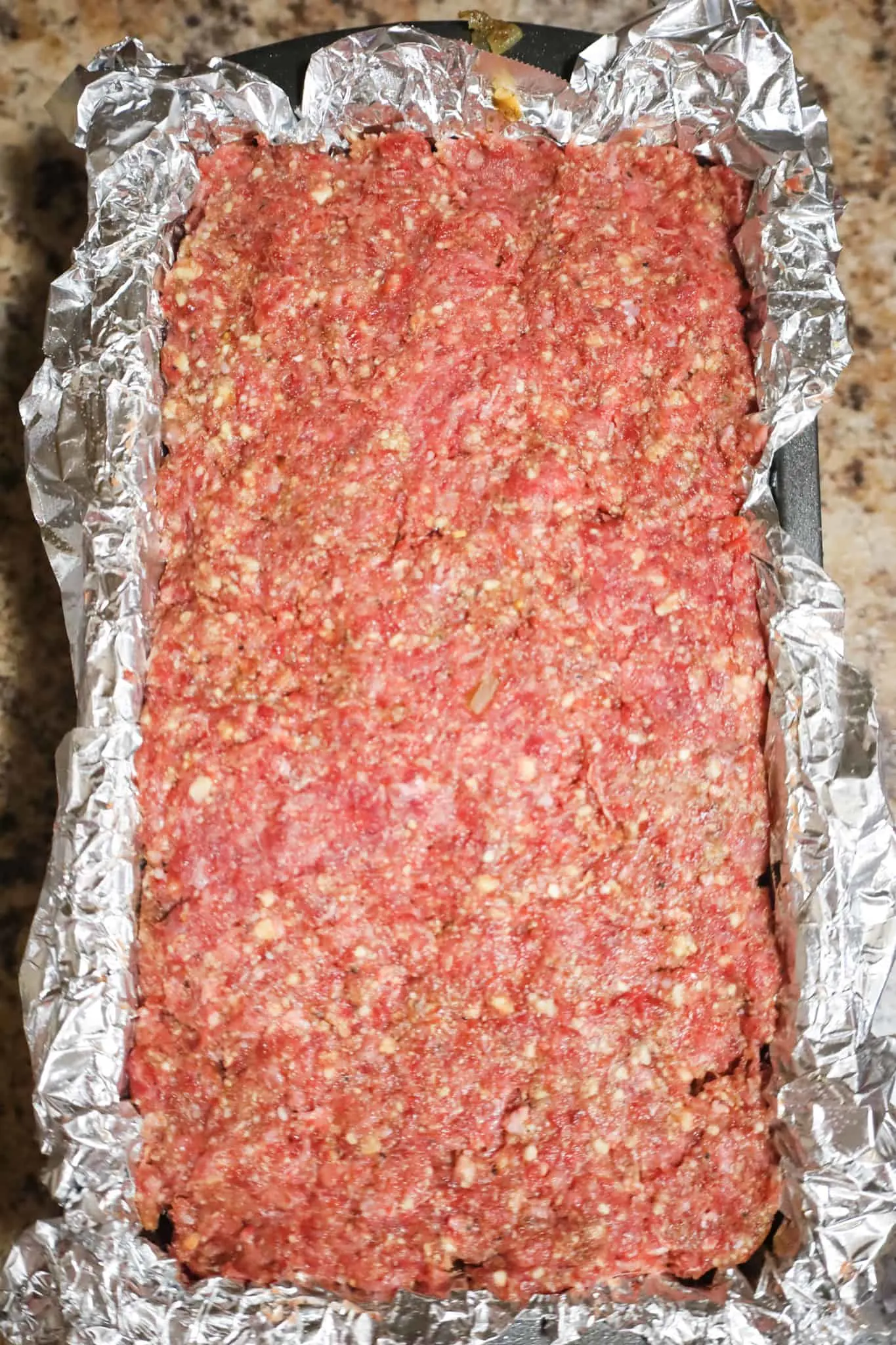 raw meatloaf mixture in a foil lined loaf pan