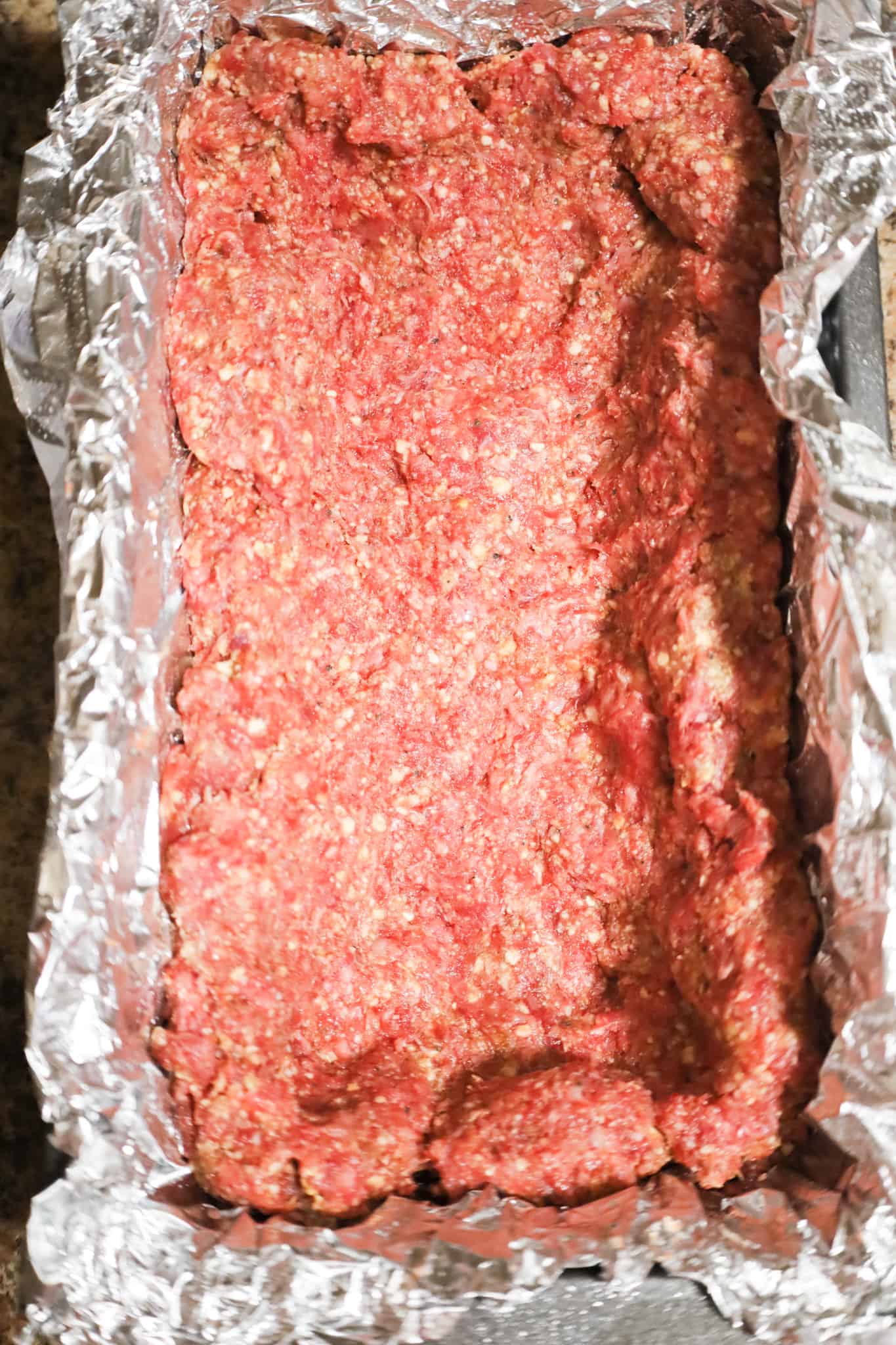 meatloaf mixture pressed into the bottom and up the sides of a loaf pan