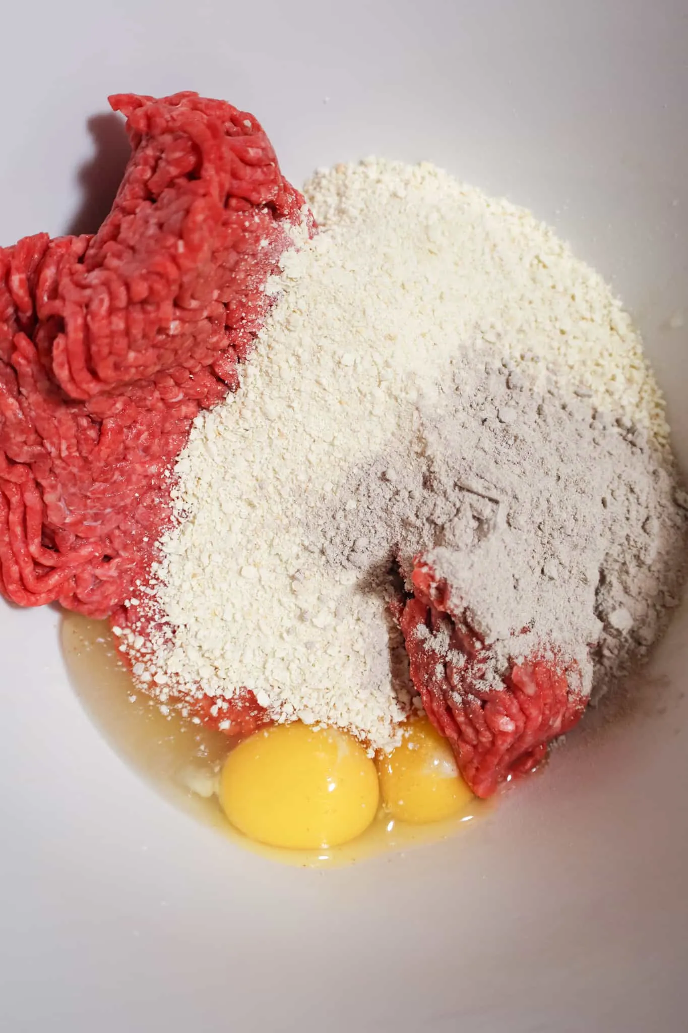 bread crumbs, gravy mix, eggs and ground beef in a mixing bowl