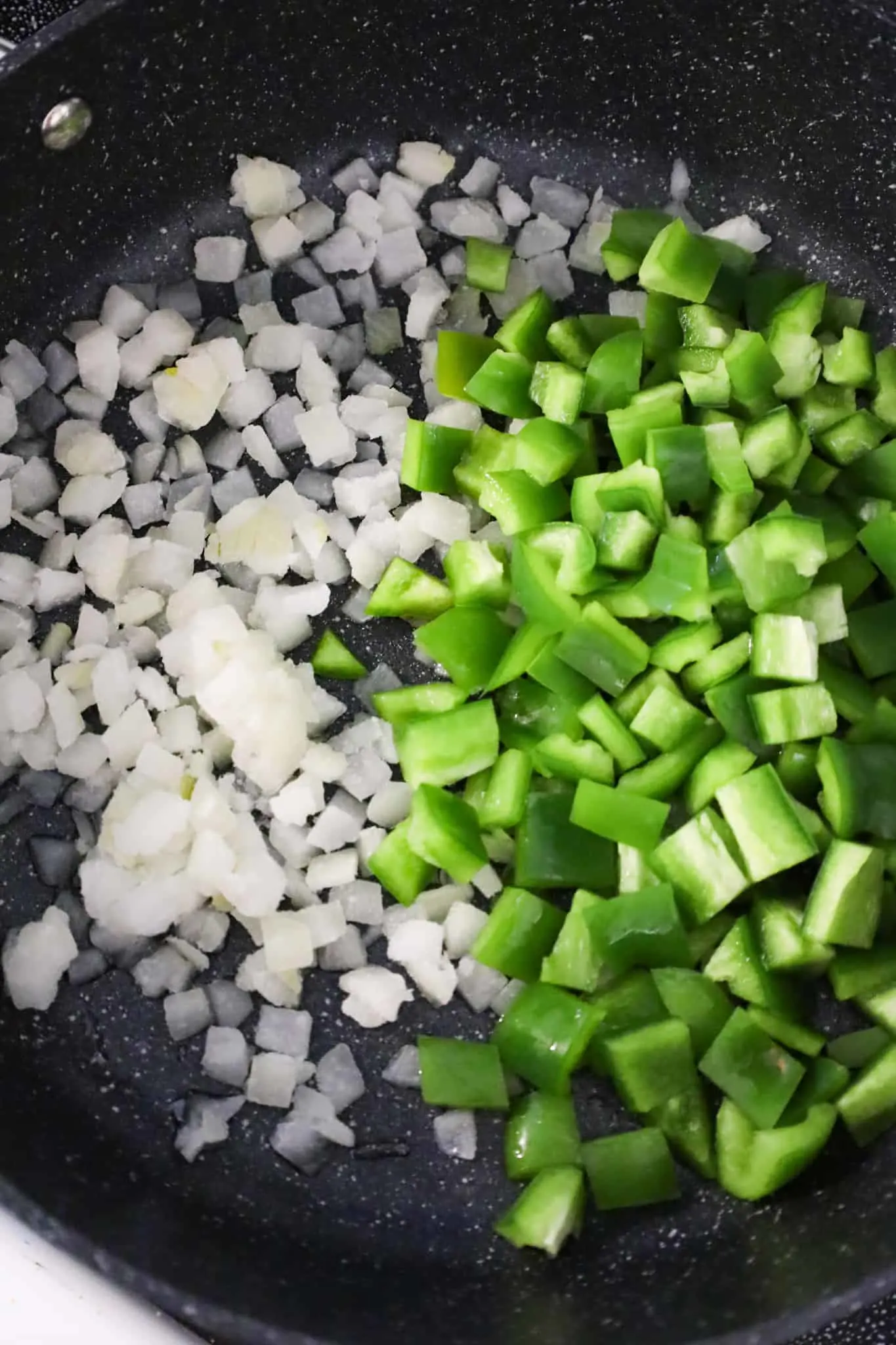 diced onions and diced green peppers in a skillet
