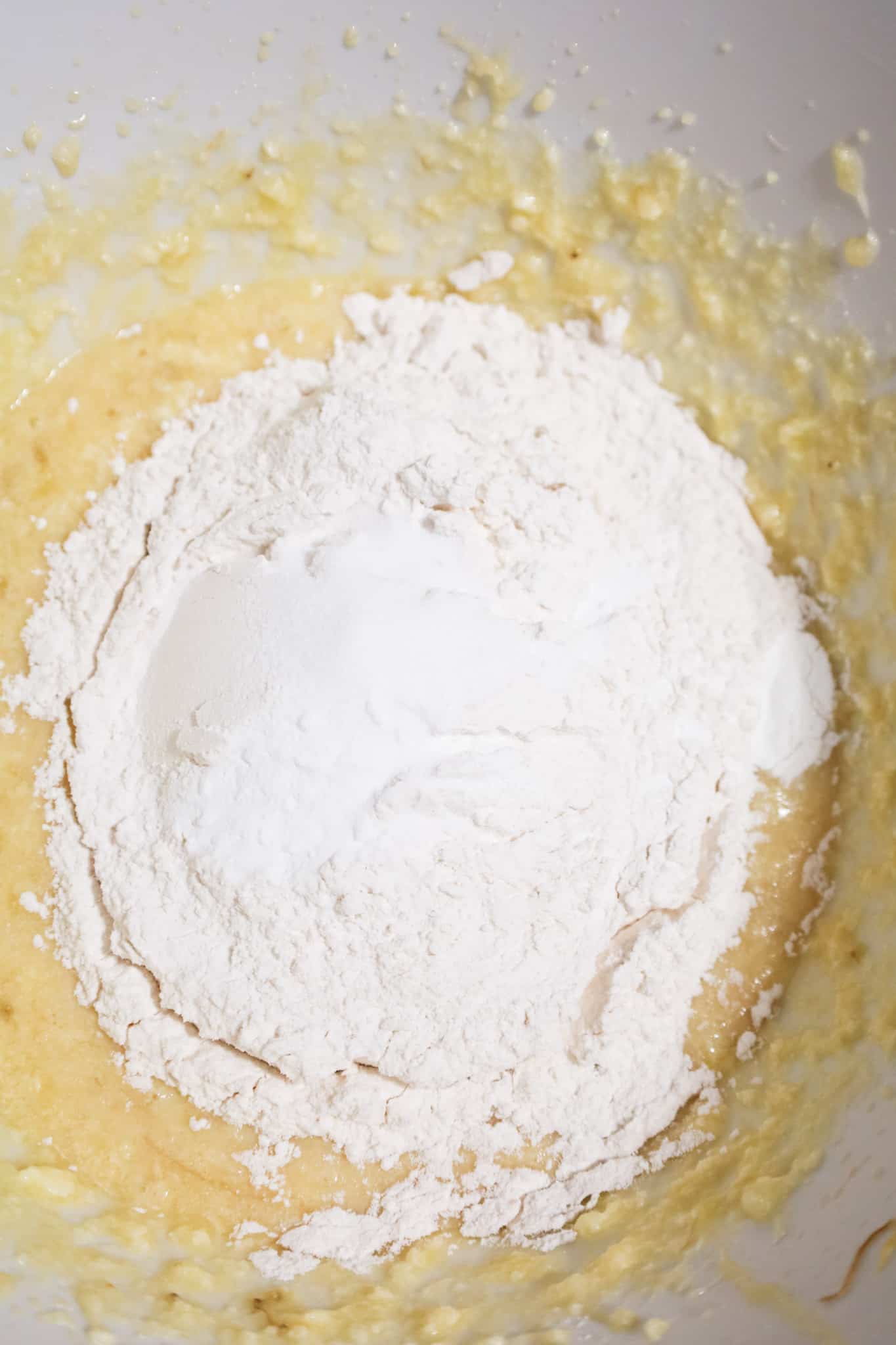 dry ingredients on top of creamed banana mixture in a mixing bowl