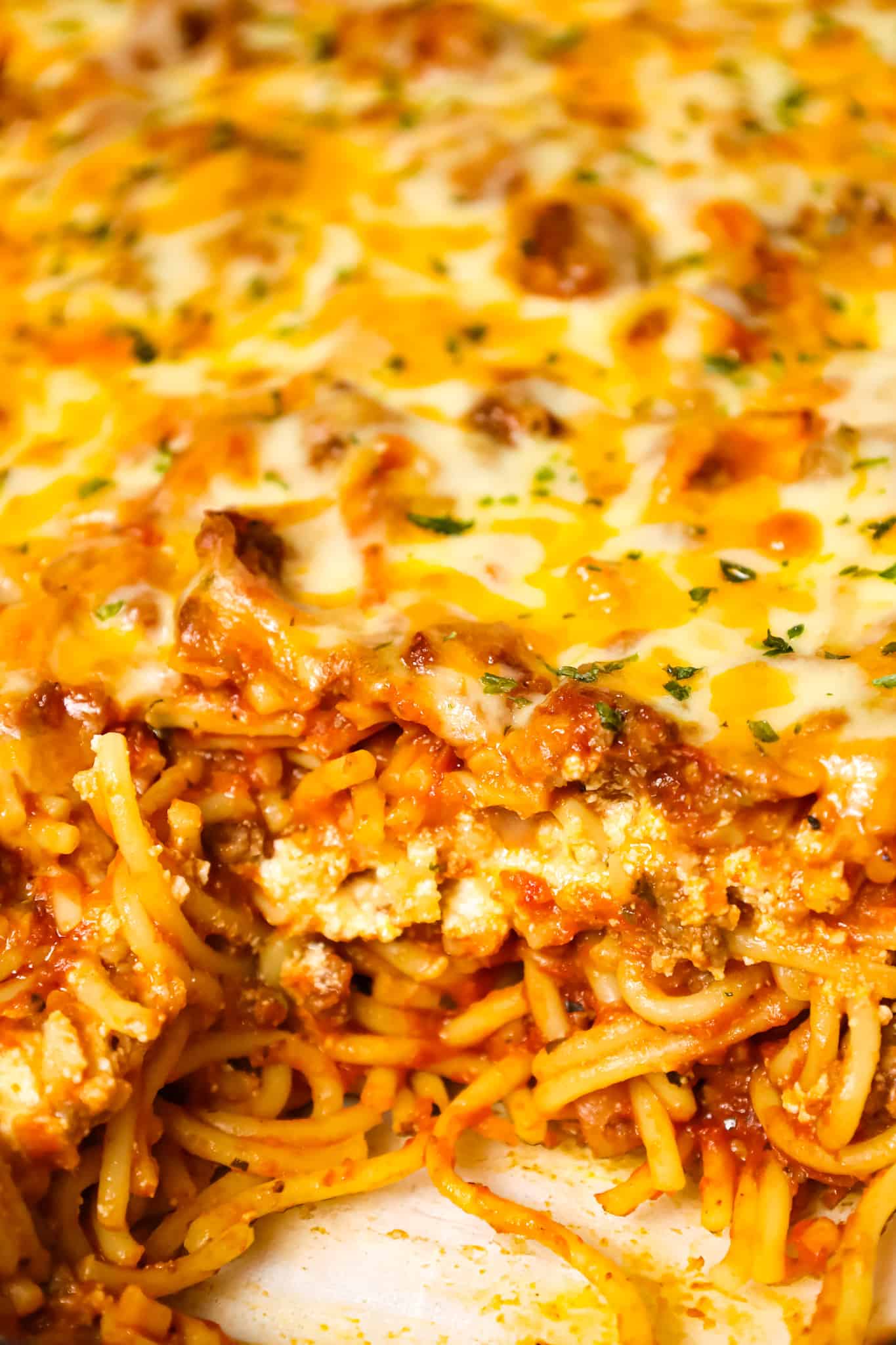 Southern Baked Spaghetti is a hearty baked pasta recipe loaded with ground beef, marinara, ricotta, parmesan, cheddar and mozzarella cheese.