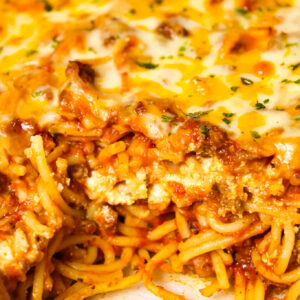 Southern Baked Spaghetti is a hearty baked pasta recipe loaded with ground beef, marinara, ricotta, parmesan, cheddar and mozzarella cheese.