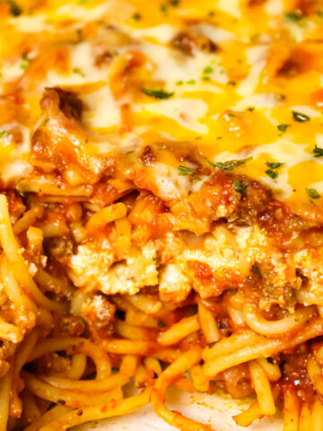 Southern Baked Spaghetti is a hearty baked pasta recipe loaded with ground beef, marinara, ricotta, parmesan, cheddar and mozzarella cheese.