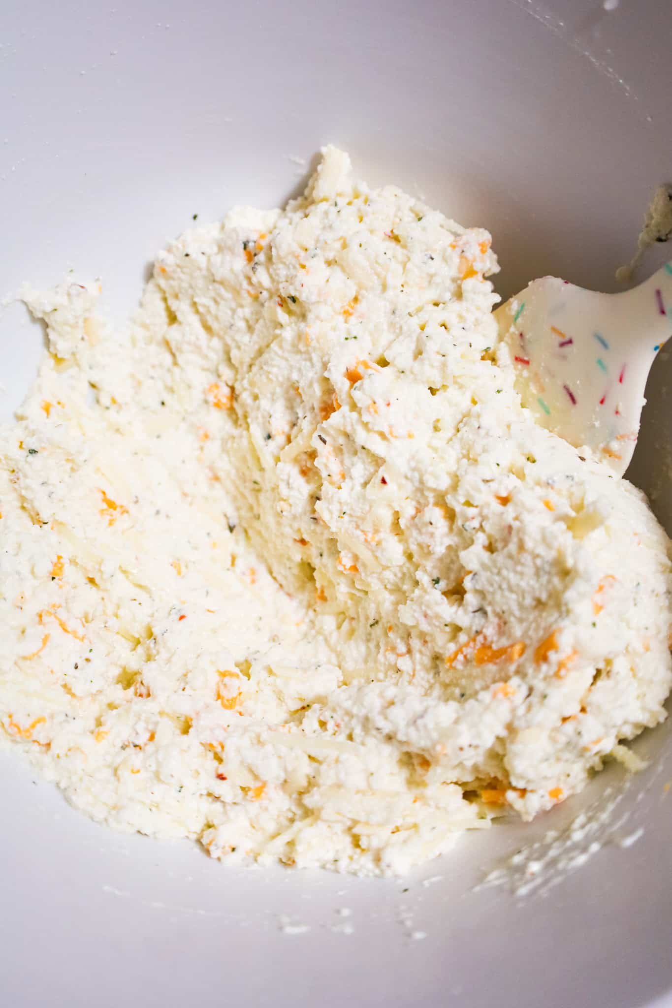 ricotta and shredded cheese mixture in a mixing bowl