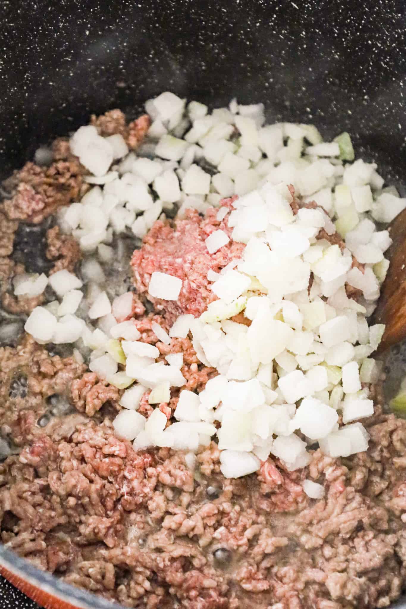diced onions on top of lean ground in a large pot