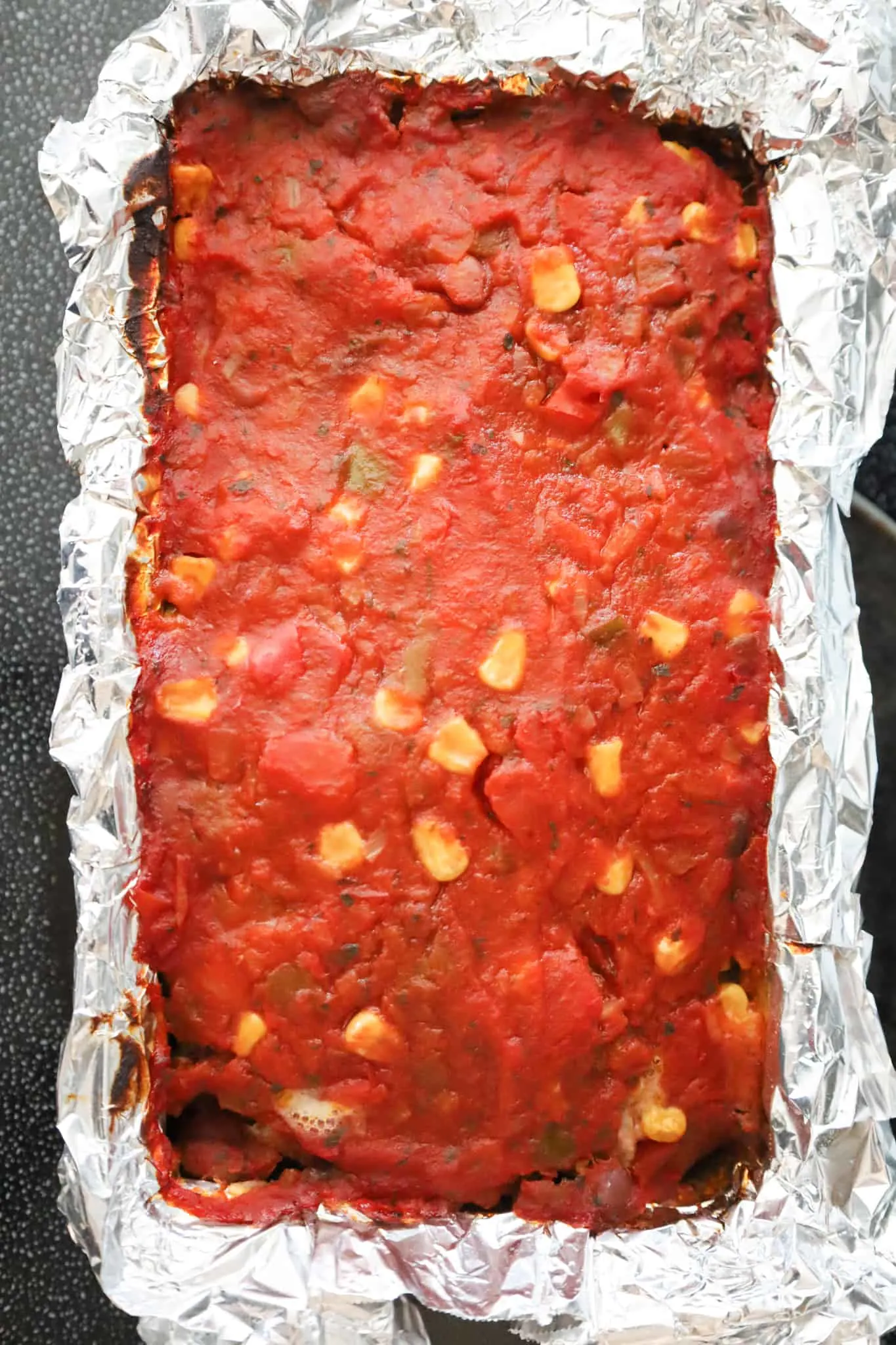 salsa on top of meatloaf in a loaf pan after baking