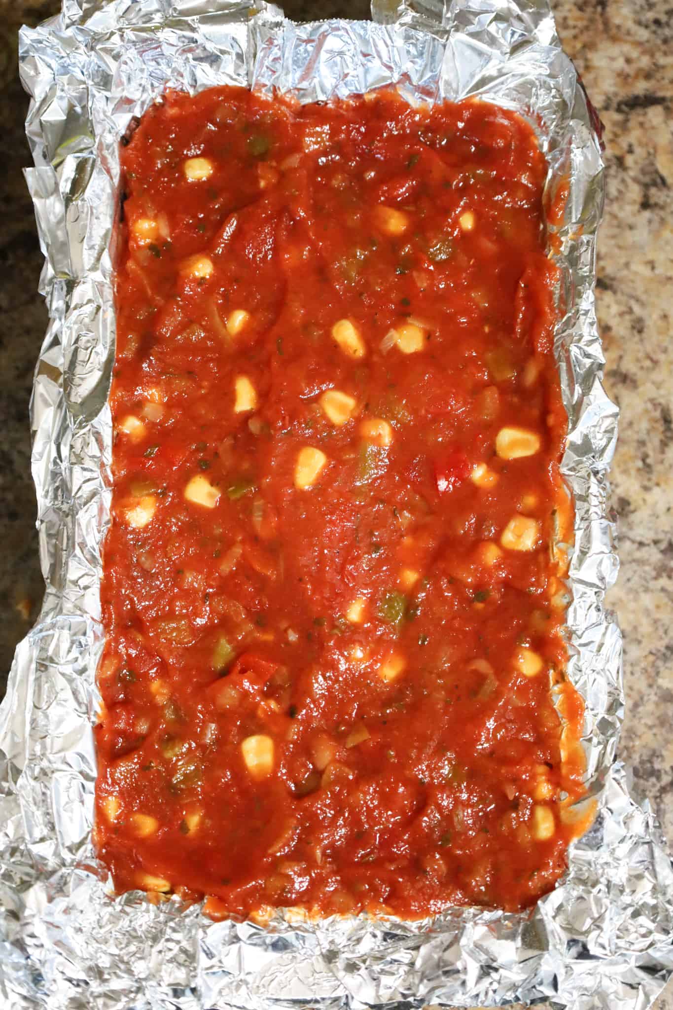 salsa on top of meatloaf in a loaf pan before baking