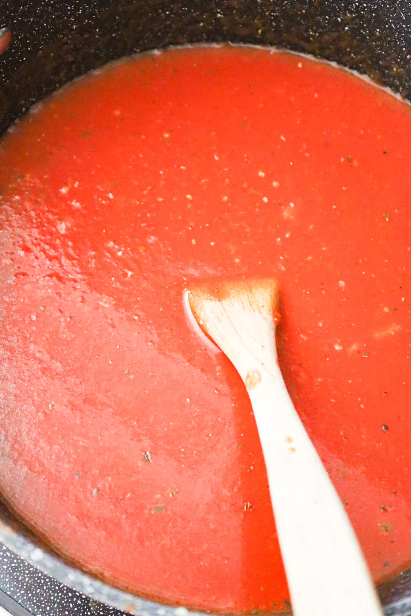 vegetable broth added to crushed tomato mixture in pot