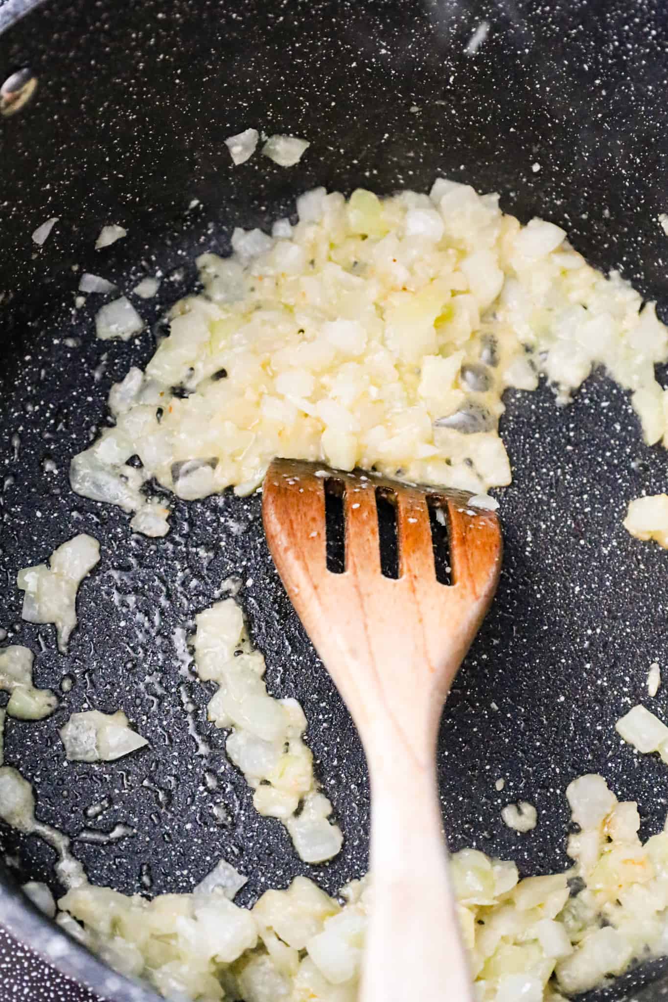 diced onions and garlic cooking in olive oil in a pot