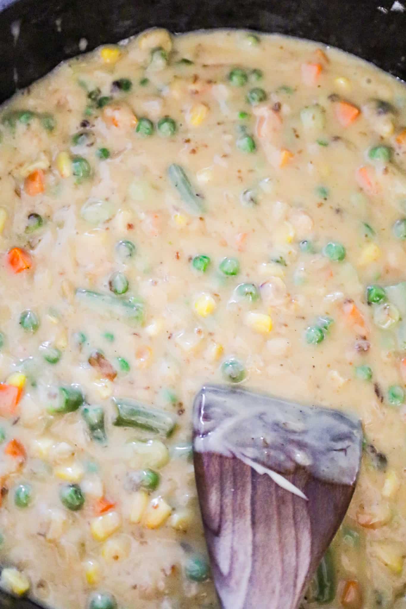 cream of chicken soup and gravy mixture with vegetables in a skillet
