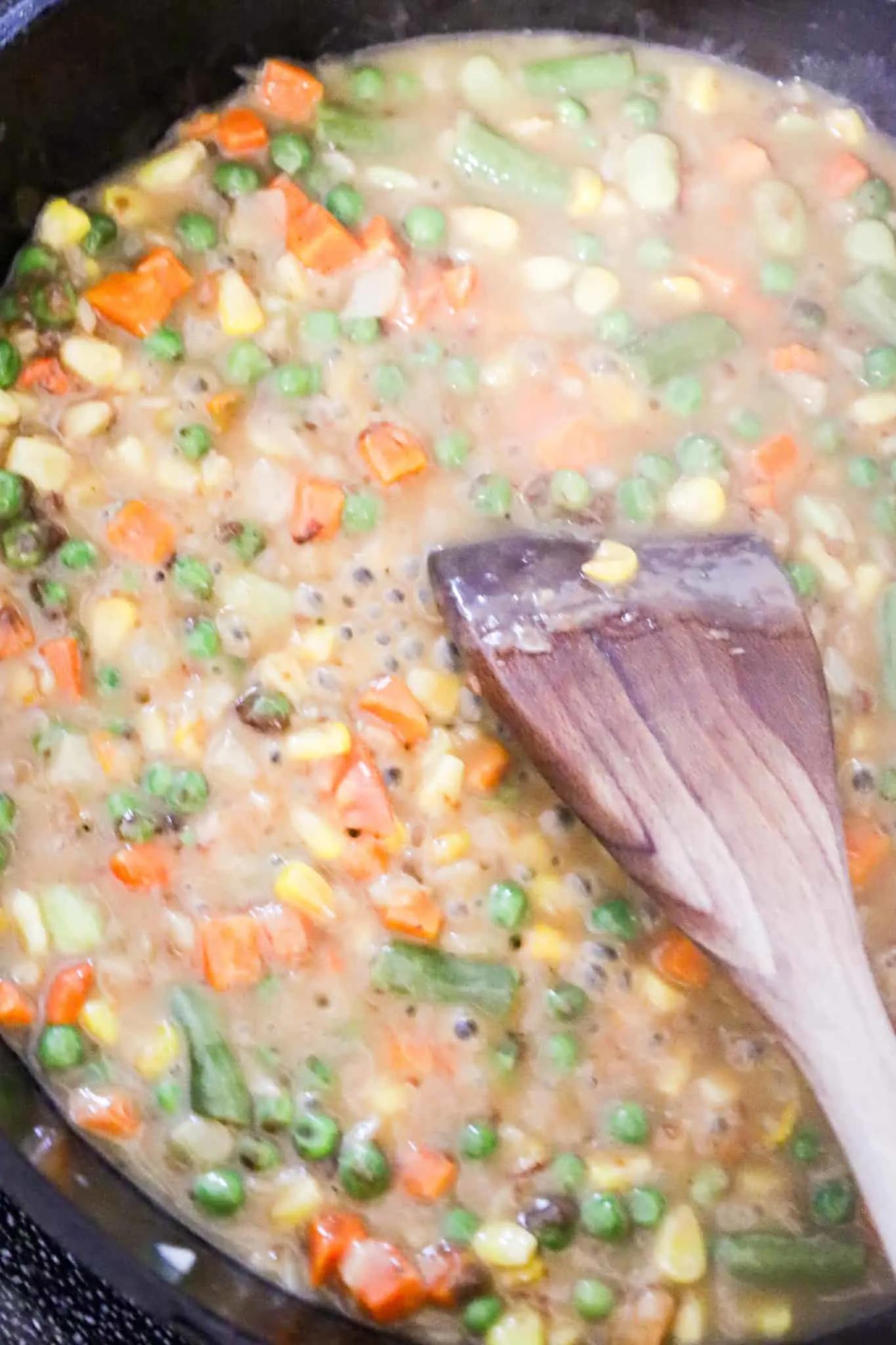 turkey gravy simmering in a skillet with mixed vegetables