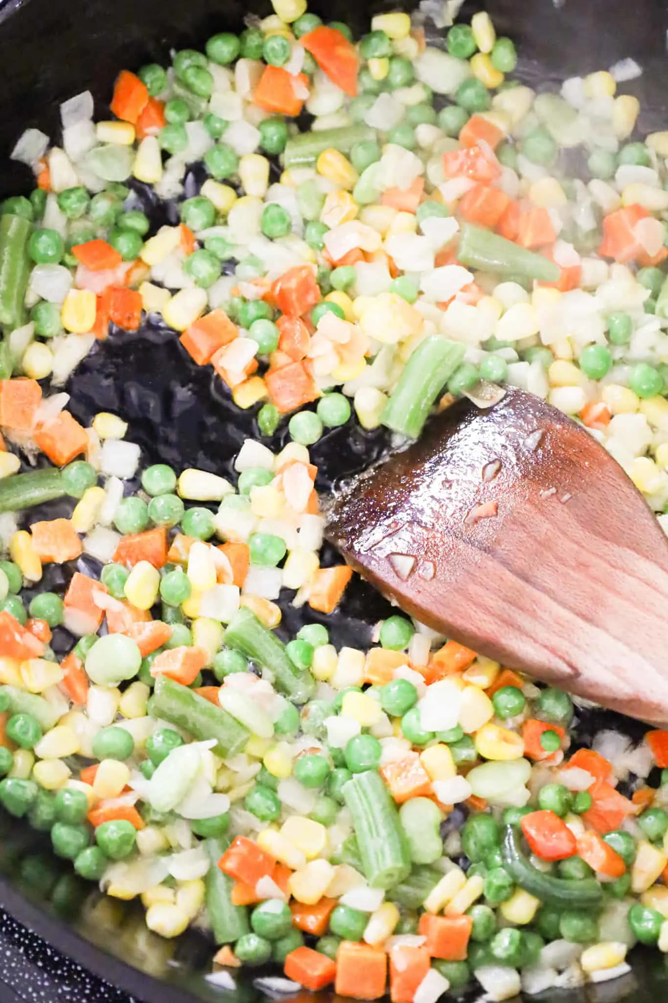 frozen veggies and onions cooking in a skillet