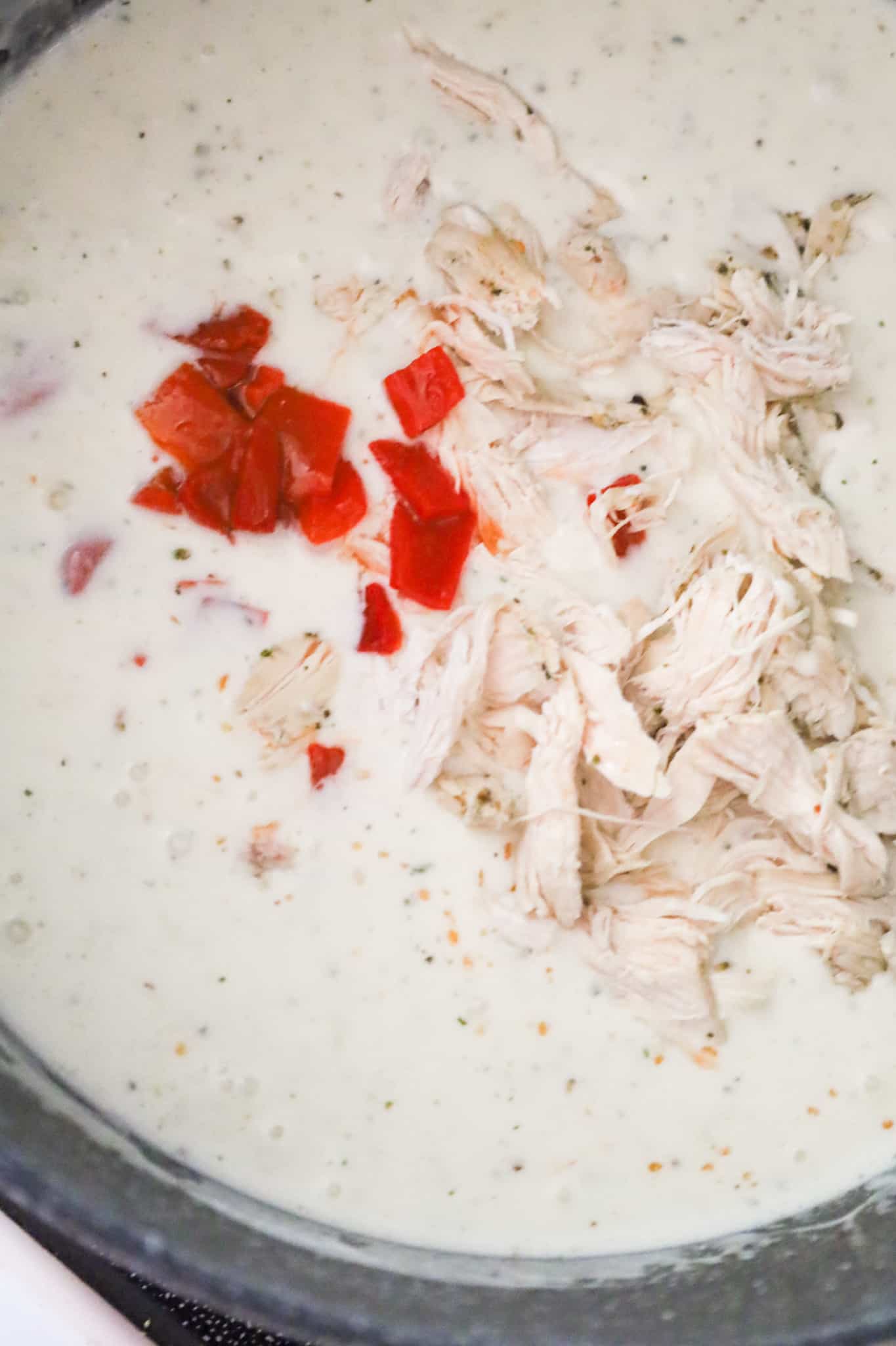 roasted red peppers and shredded chicken added to creamy soup mixture