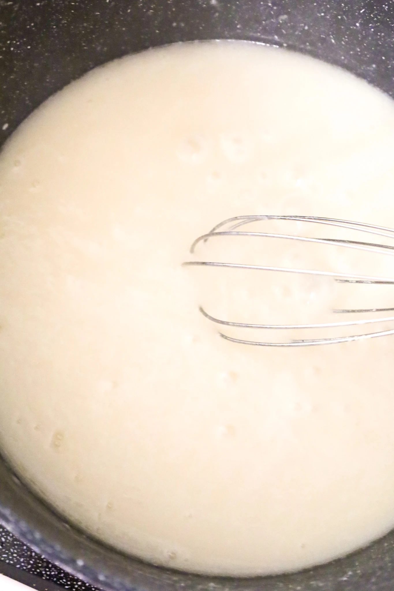 whisking broth and flour mixture together in a large pot
