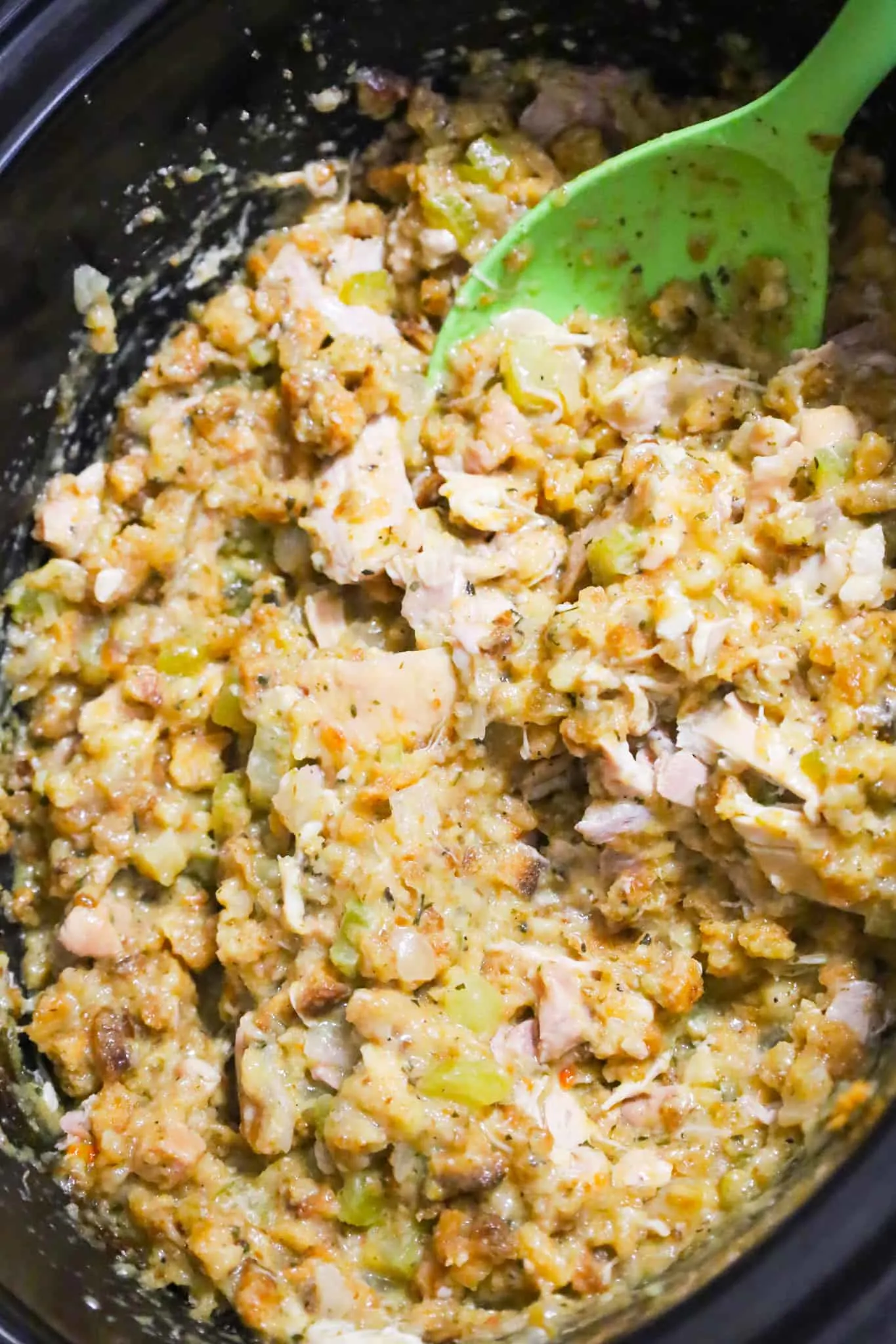 stirring chicken and stuffing mixture in a crock pot
