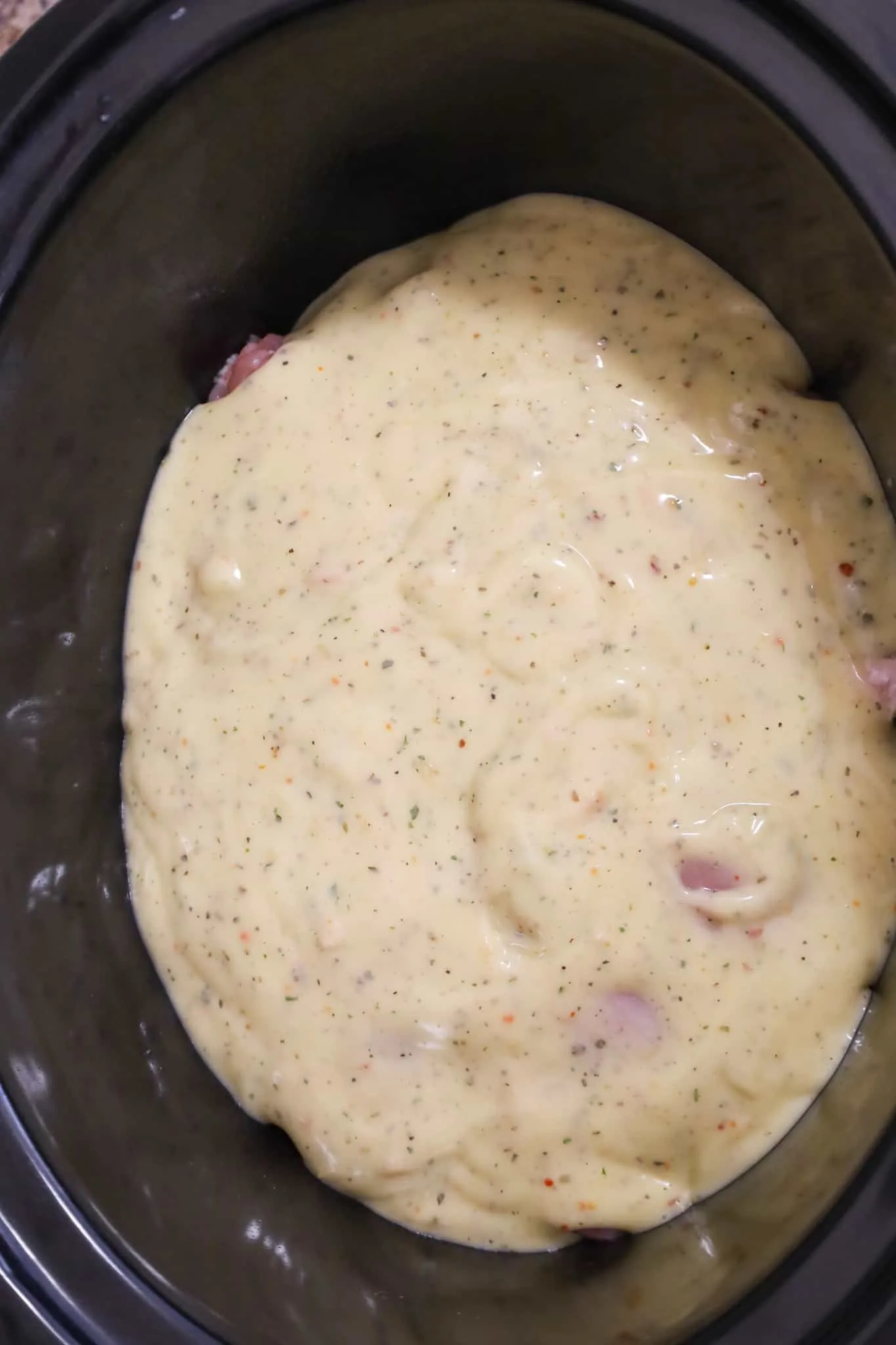 cream of chicken soup poured over chicken thighs in a crock pot