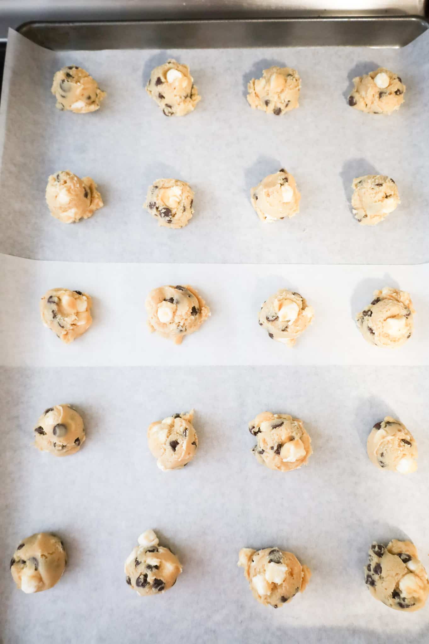 chocolate chip marshmallow cookie dough balls on a parchment lined baking sheet