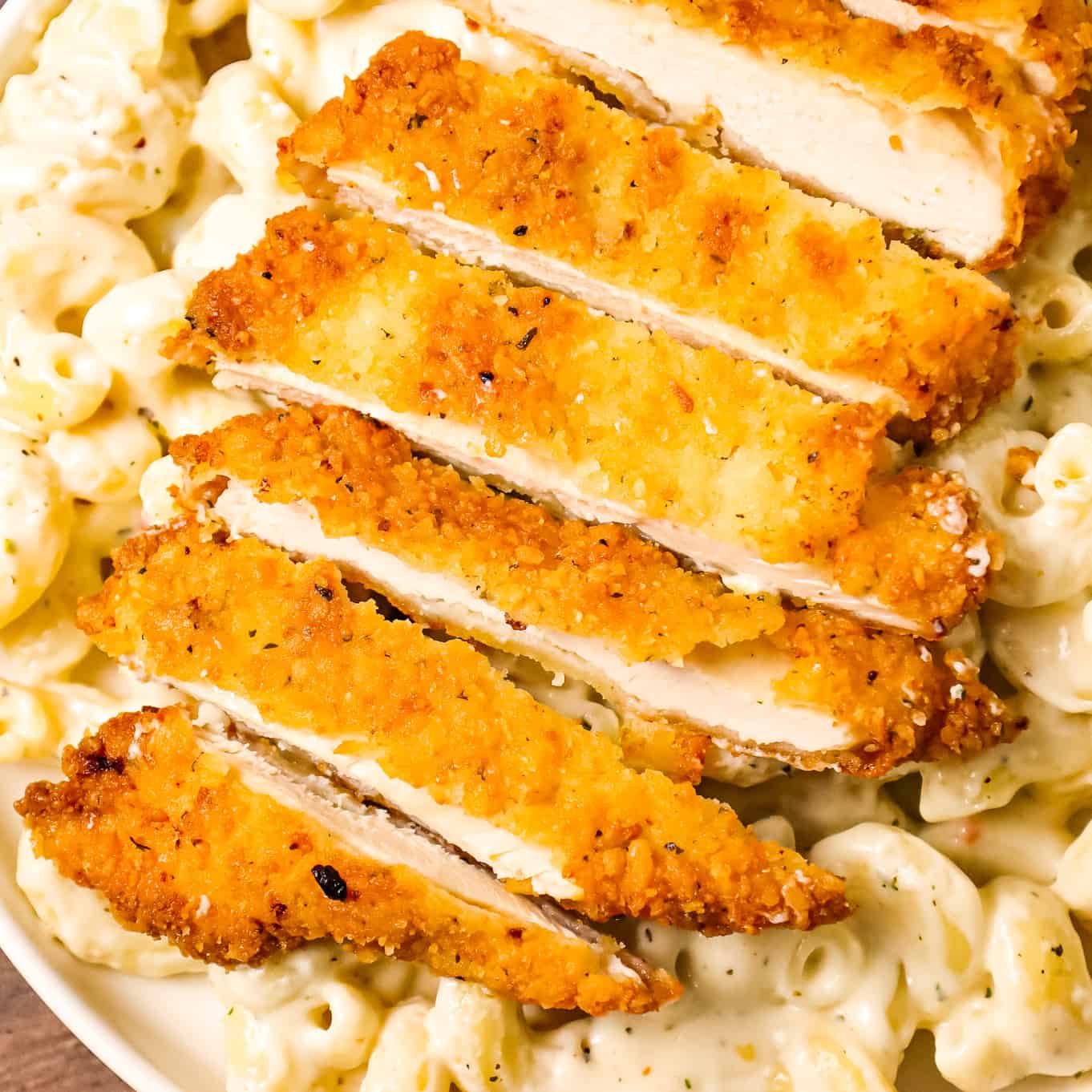 Crispy Chicken Fritta is delicious parmesan crusted chicken breasts served over creamy garlic and asiago cheese cavatappi pasta.