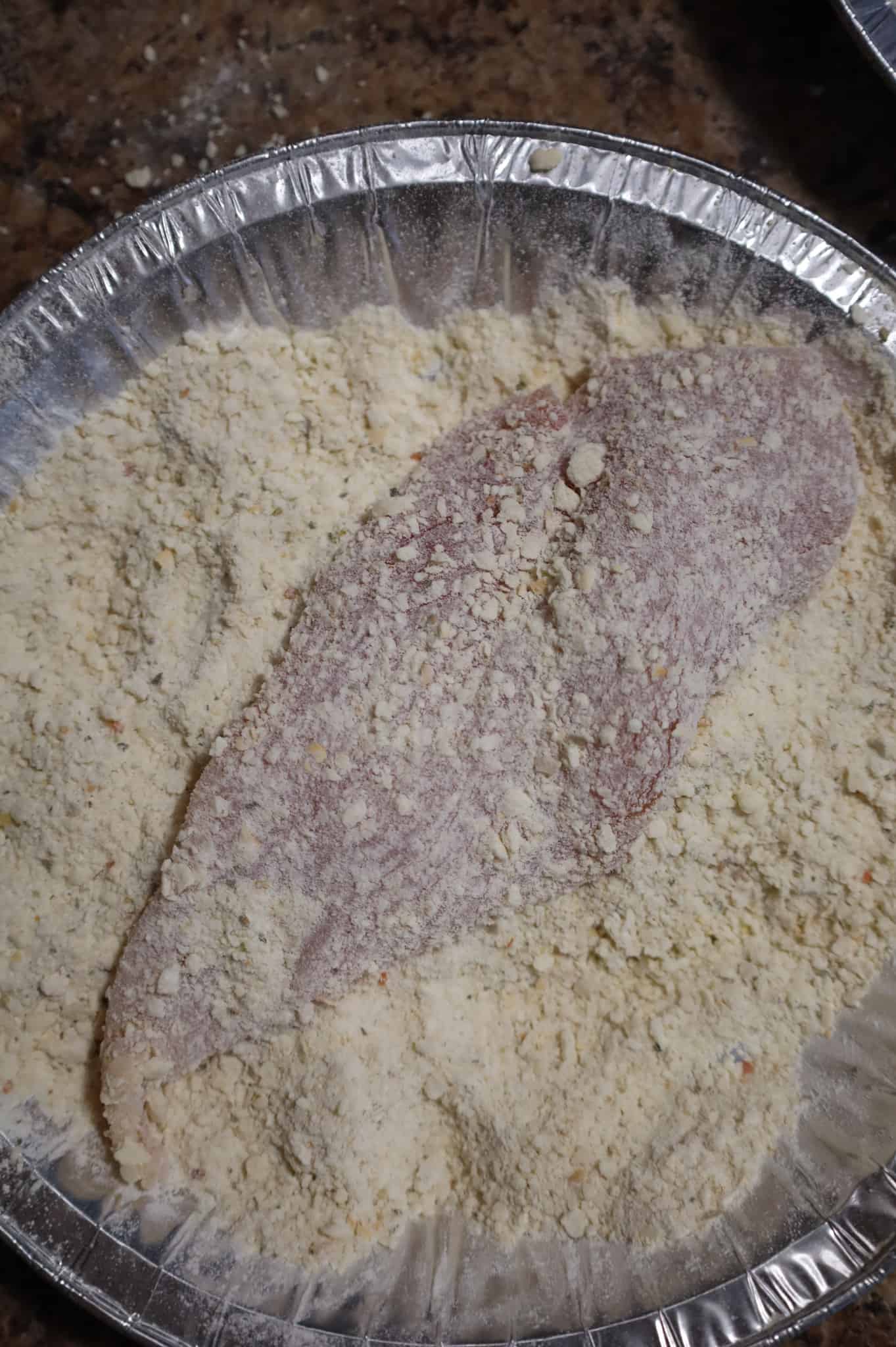 chicken breast half in bread crumb mixture