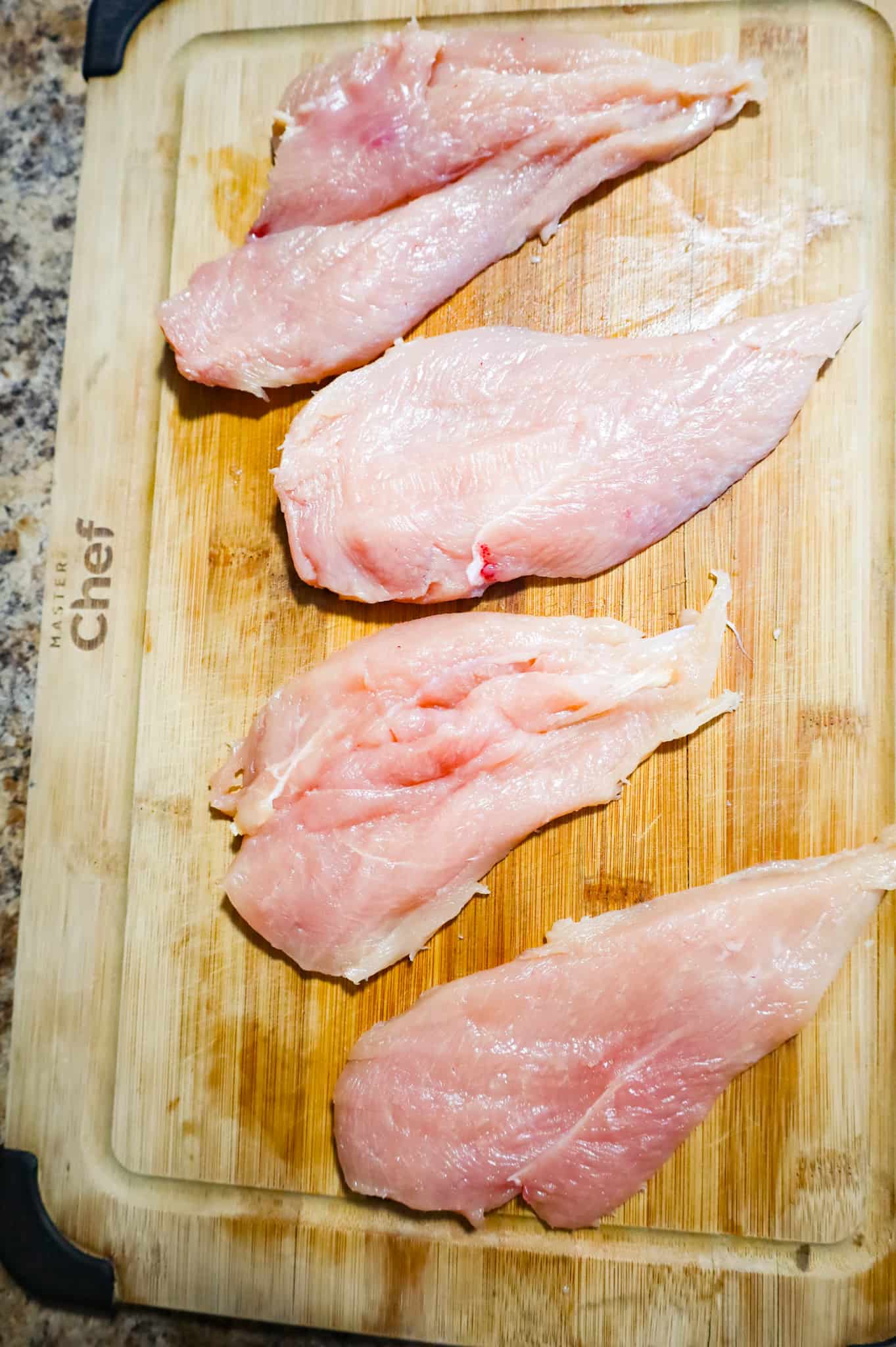 chicken breast halves on a cutting board
