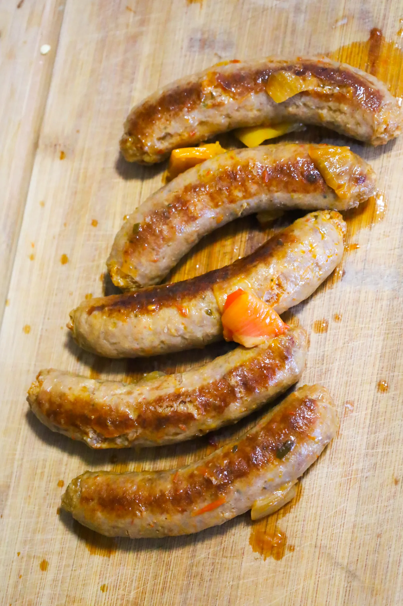 cooked Italian sausages on a cutting board