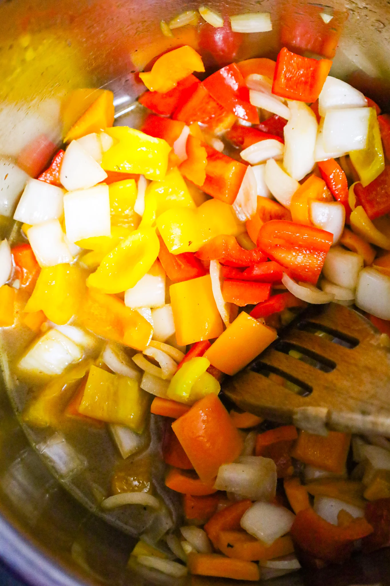 diced onions and sweet bell peppers in an Instant Pot with chicken broth