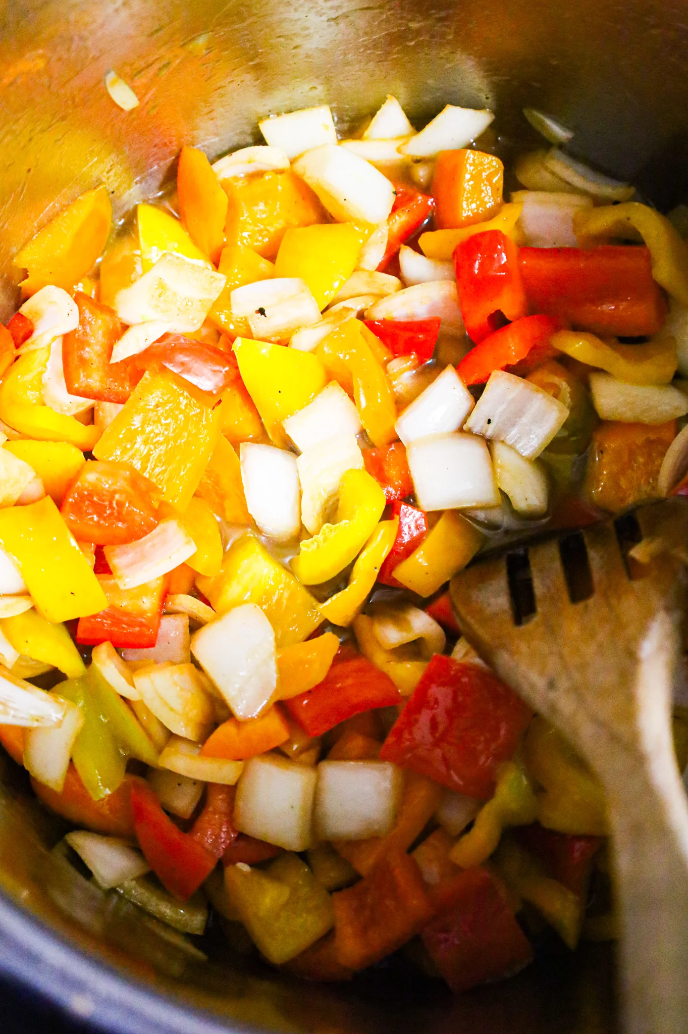 stirring diced onions and sweet bell peppers in an Instant Pot