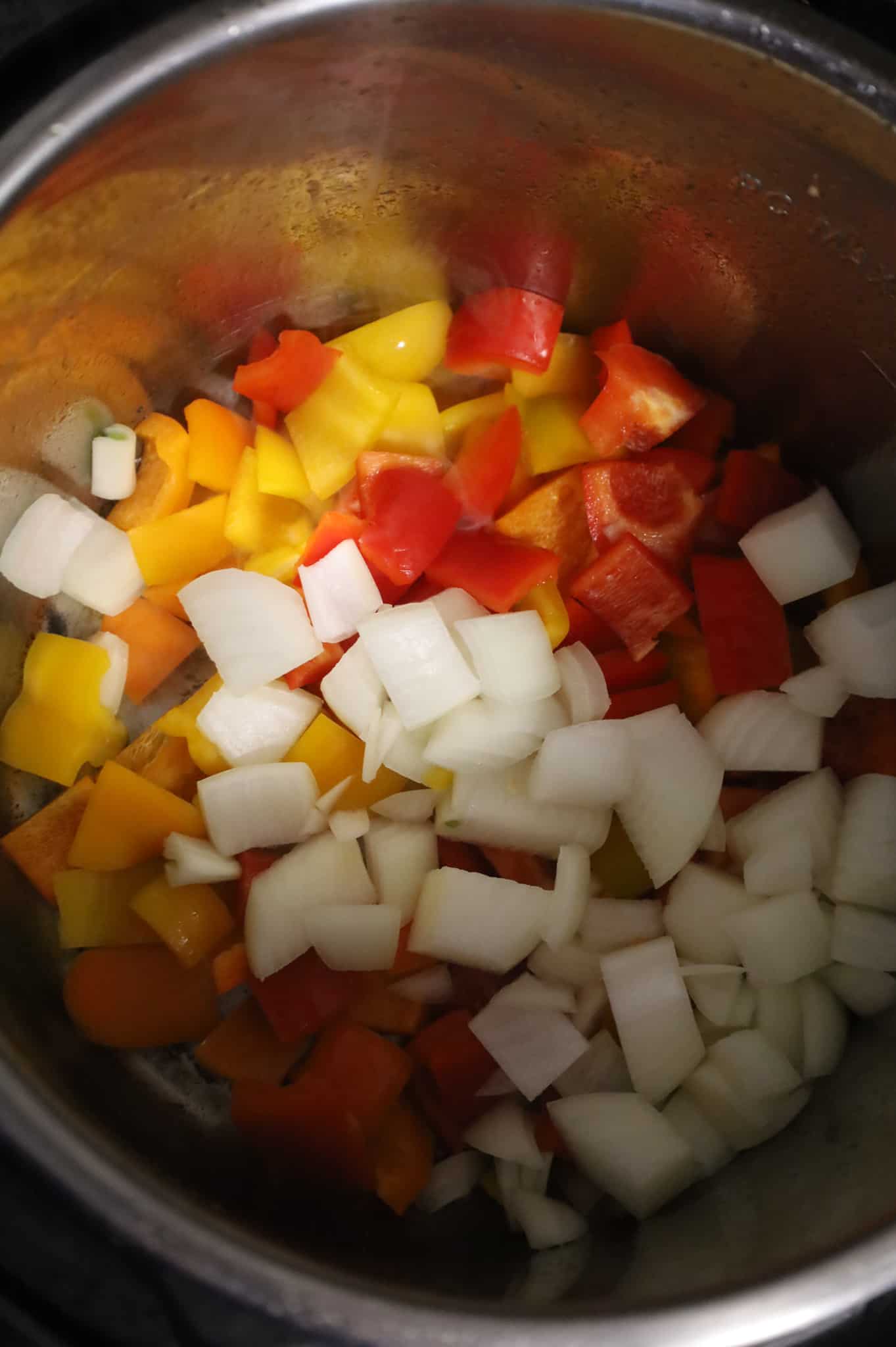 diced onions and sweet bell peppers in an Instant Pot