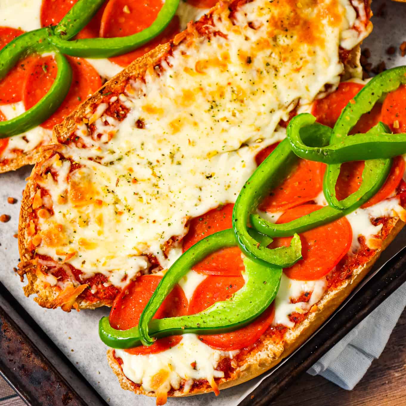 Pizza Subs are an easy weeknight dinner recipe using 9 inch sub rolls loaded with pizza sauce, mozzarella cheese, pepperoni and green peppers and then baked until perfectly toasted.