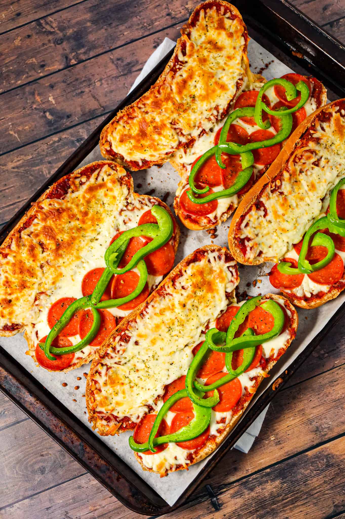 Pizza Subs are an easy weeknight dinner recipe using 9 inch sub rolls loaded with pizza sauce, mozzarella cheese, pepperoni and green peppers and then baked until perfectly toasted.