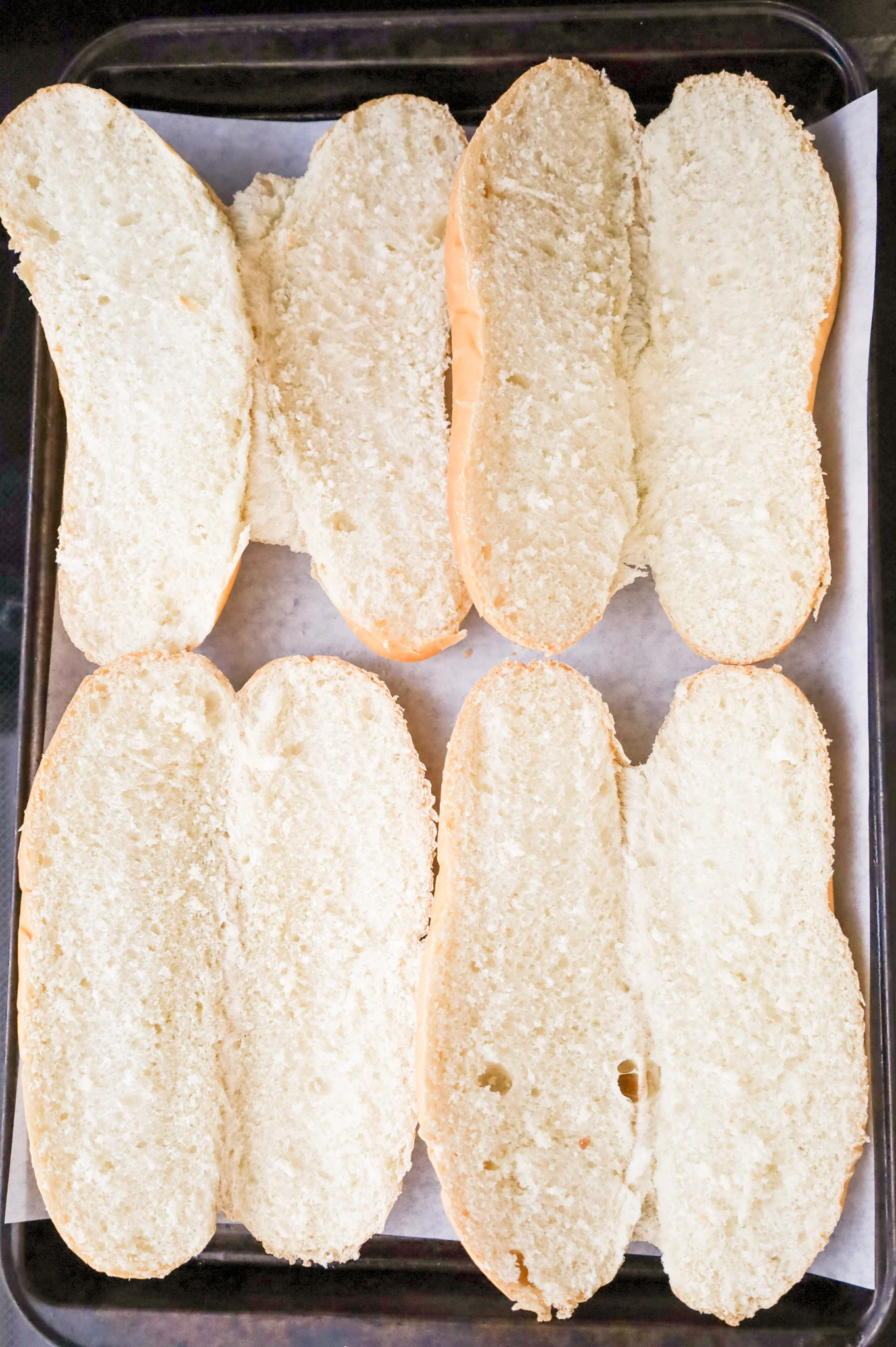 white sub buns on a parchment lined baking sheet