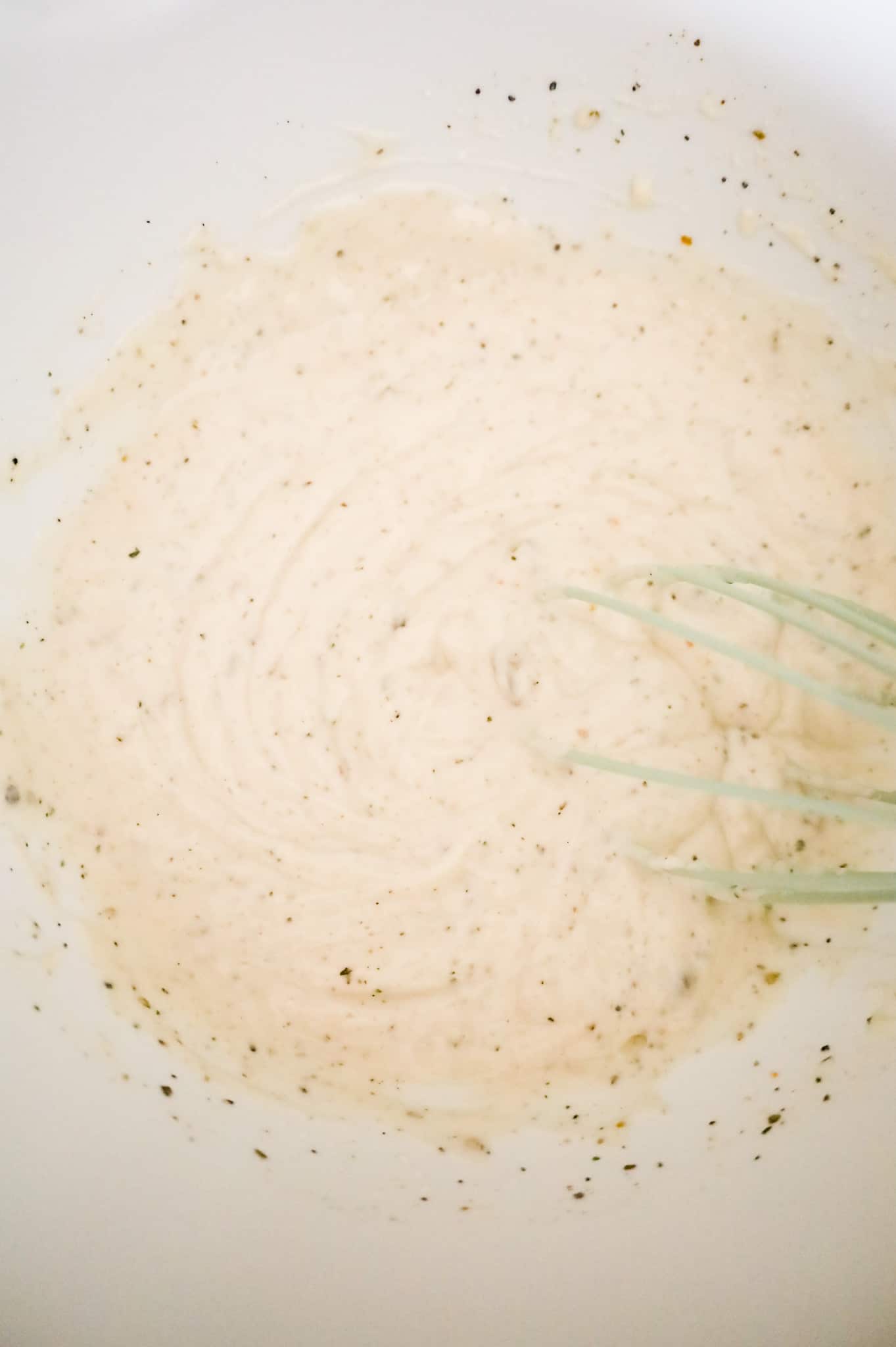 cream of mushroom soup and sour cream mixture being whisked in a mixing bowl