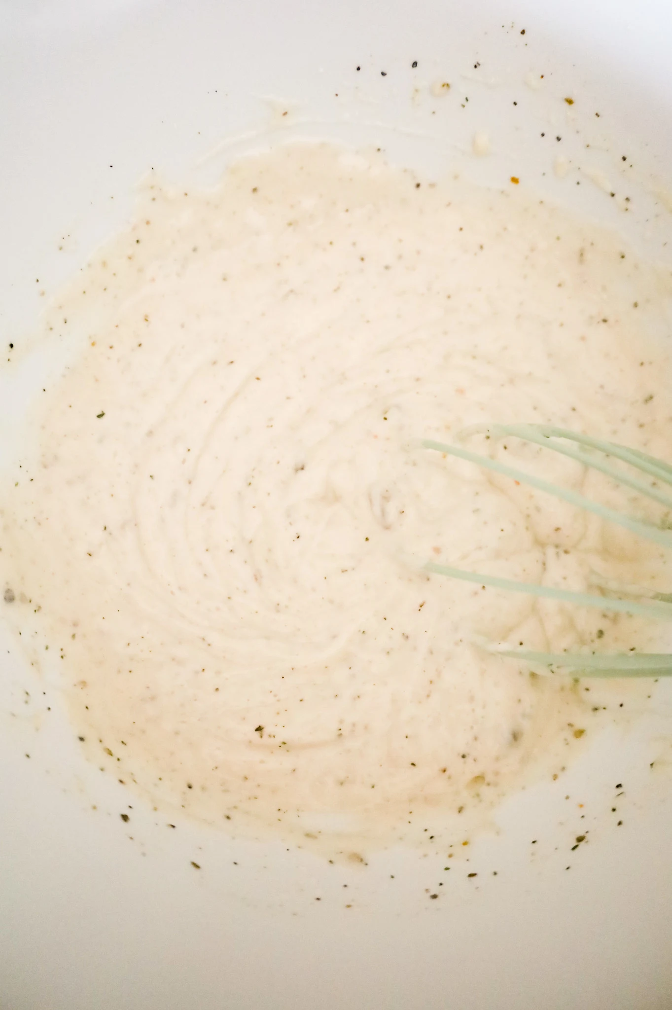 cream of mushroom soup and sour cream mixture being whisked in a mixing bowl