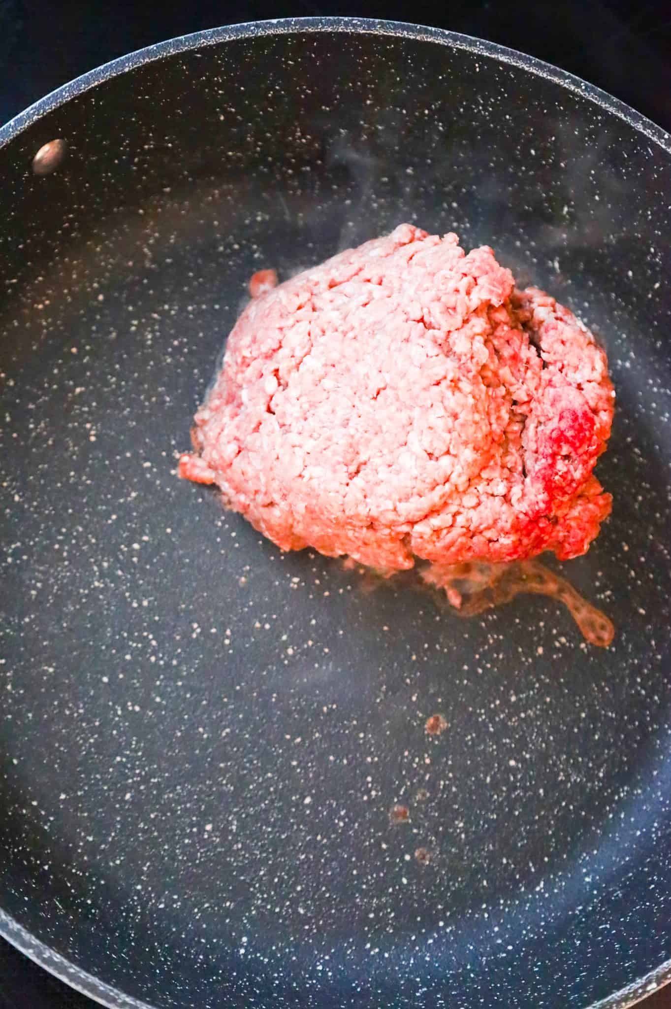 raw ground beef in a skillet