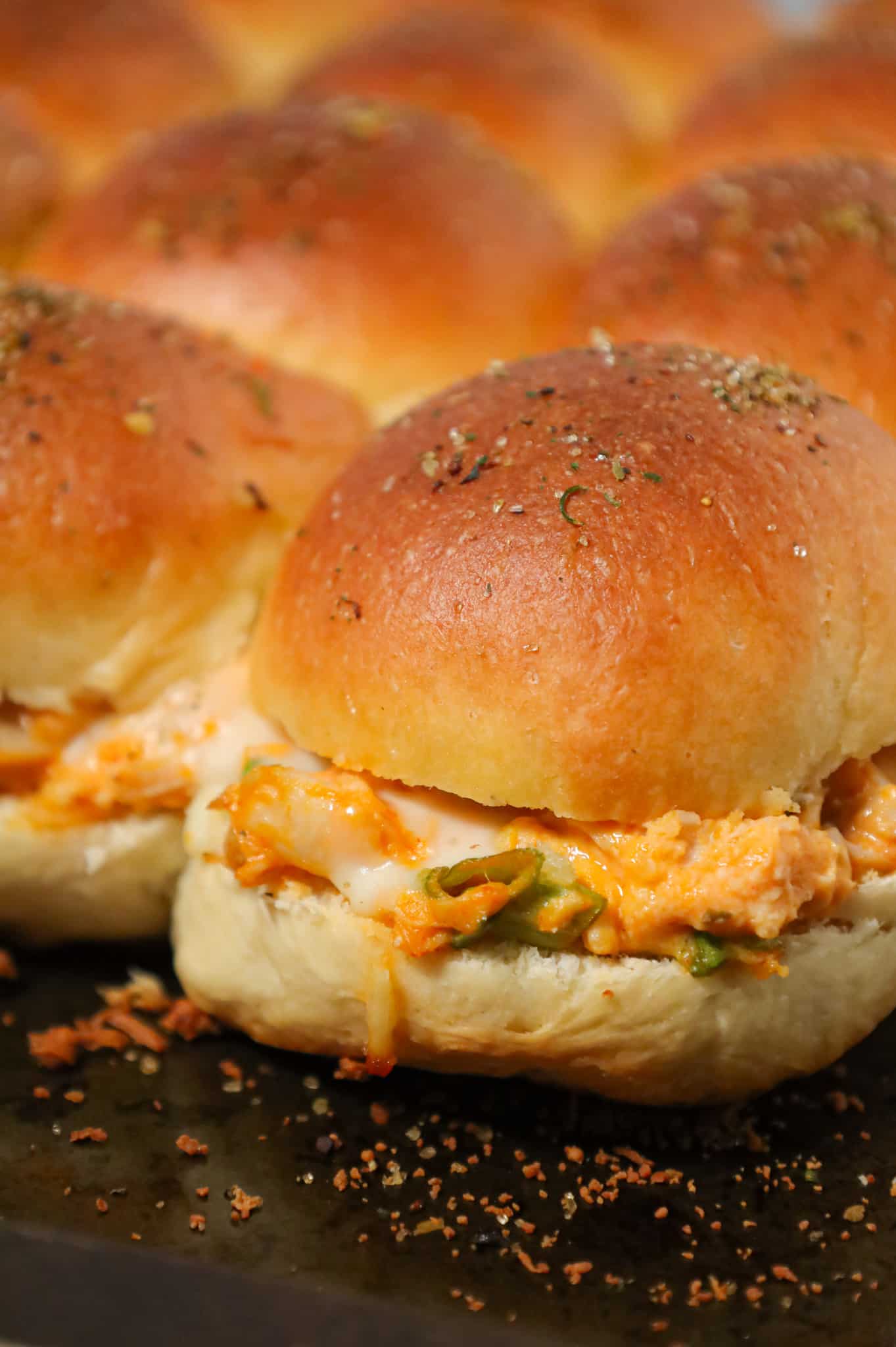 Buffalo Chicken Sliders are an easy weeknight dinner recipe using shredded rotisserie chicken, Buffalo sauce, ranch dressing, shredded cheese and chopped green onions all baked on dinner rolls.