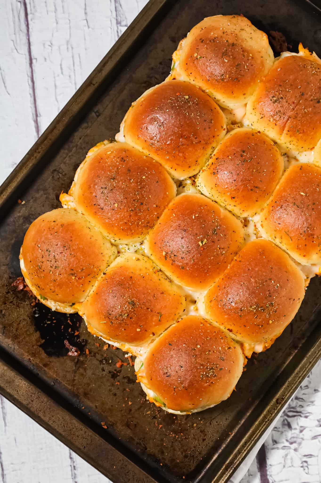 Buffalo Chicken Sliders are an easy weeknight dinner recipe using shredded rotisserie chicken, Buffalo sauce, ranch dressing, shredded cheese and chopped green onions all baked on dinner rolls.