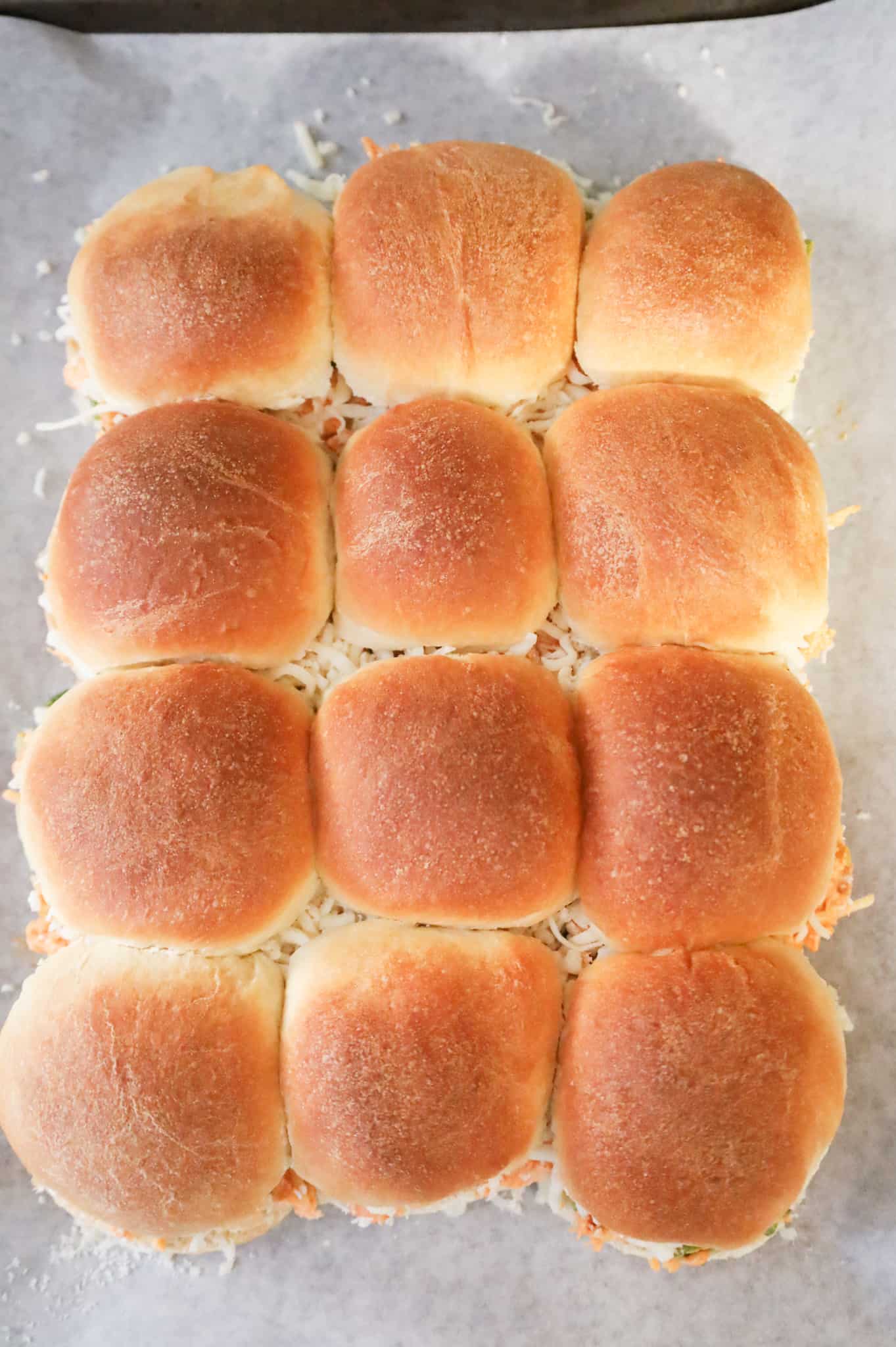 Buffalo chicken sliders on a baking sheet before baking