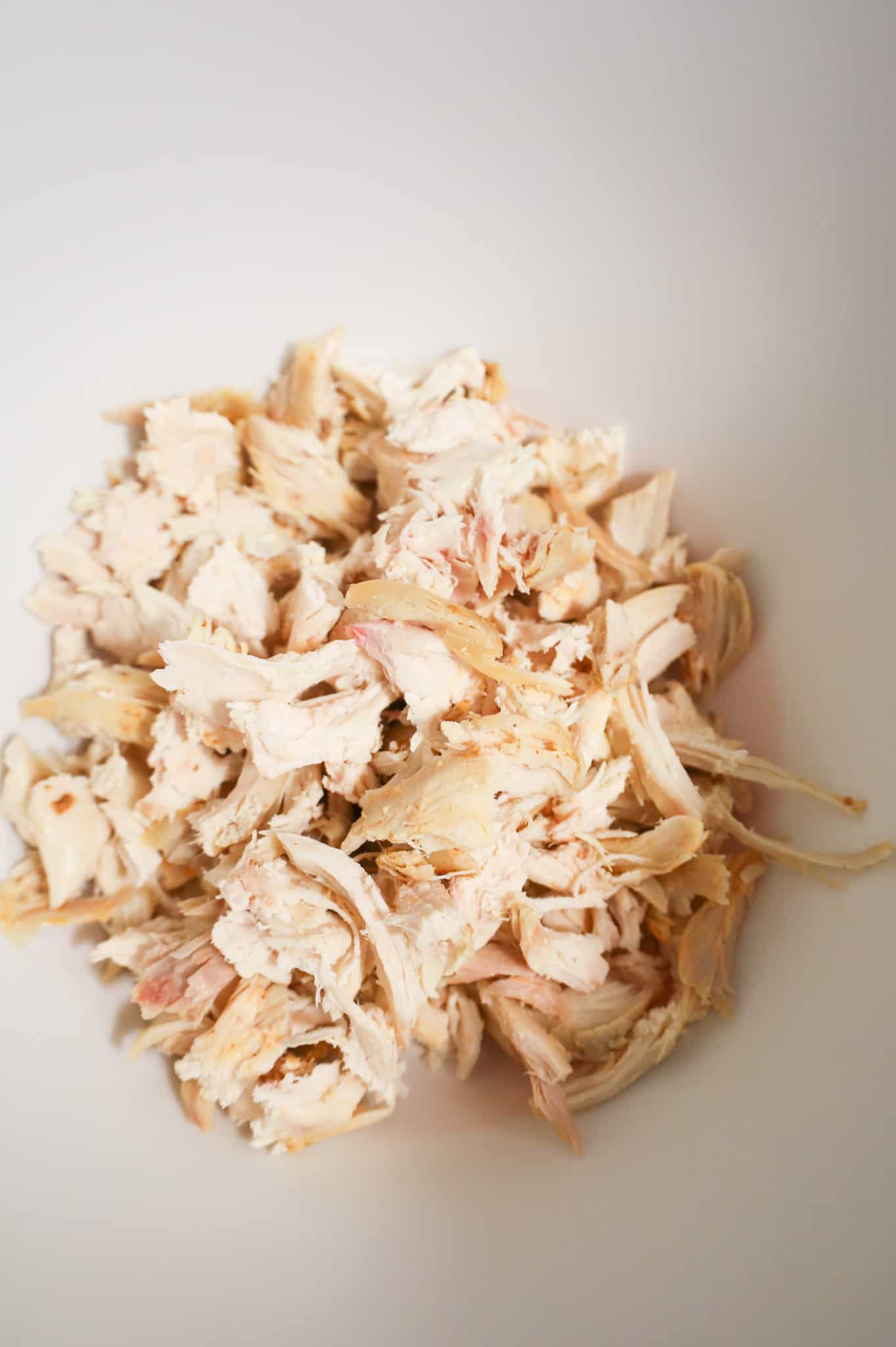 shredded rotisserie chicken in a mixing bowl